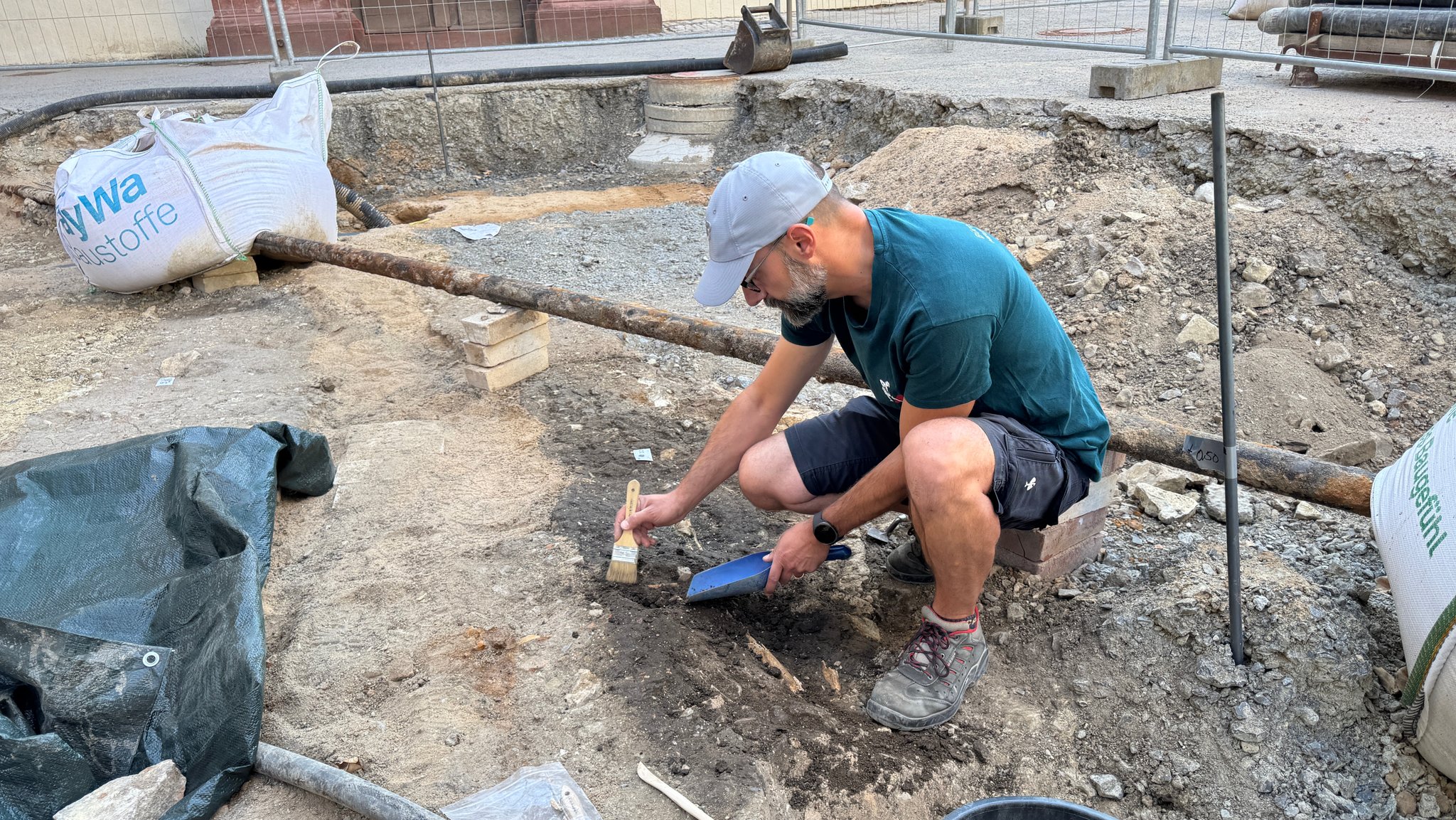Archäologe Luigi Corrado säubert mit einem Pinsel die Knochen im Boden