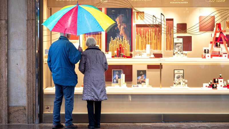 Zwei Personen im Rentenalter stehen bei Regen vor einem Schaufenster eines Schmuckgeschäfts und betrachten die ausgestellten Waren. | Bild: dpa-Bildfunk/Sina Schuldt Zwei Personen im Rentenalter stehen bei Regen vor einem Schaufenster eines Schmuckgeschäfts und betrachten die ausgestellten Waren.
