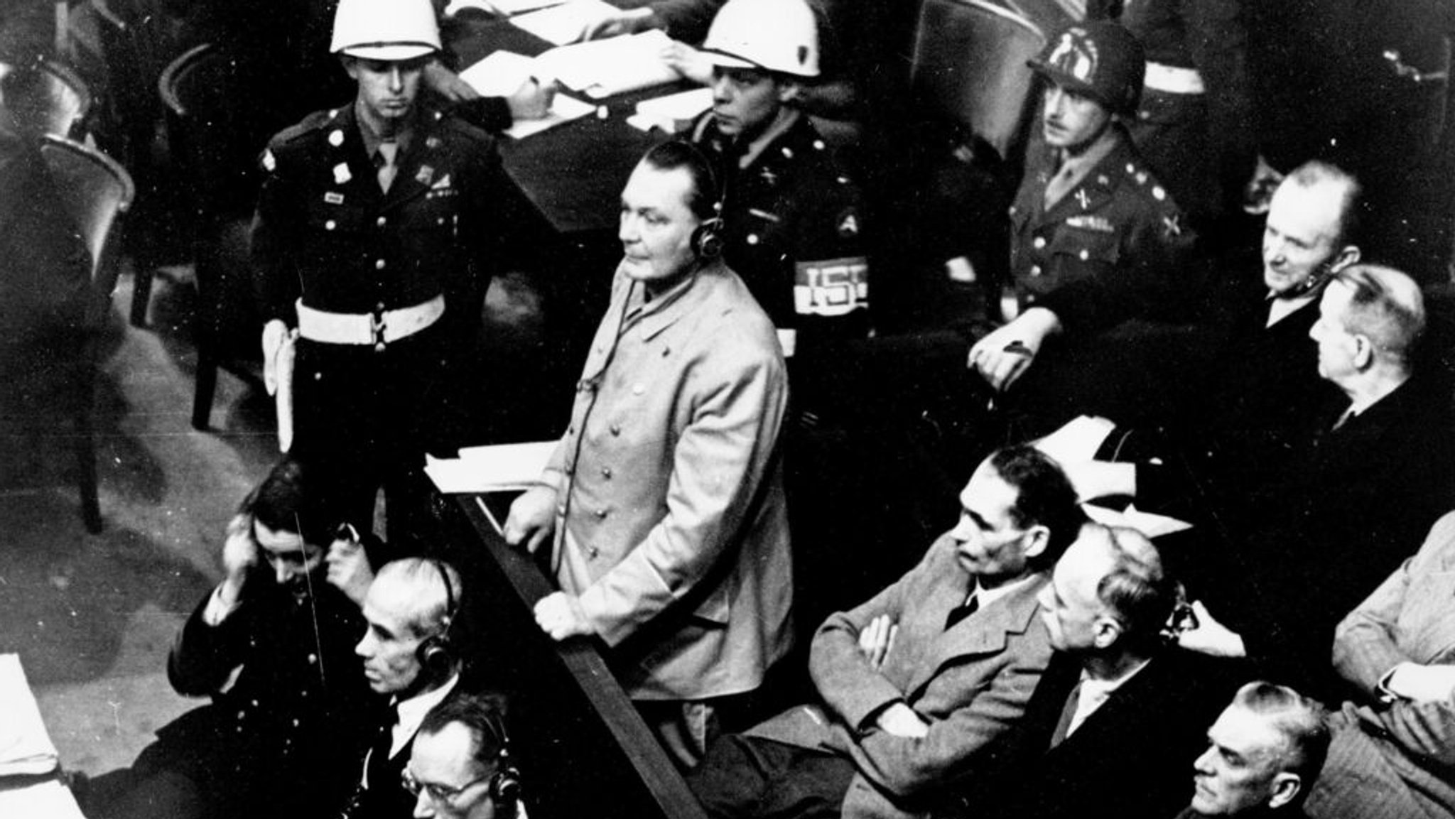ARCHIV - 21.11.1945, NA, Nürnberg: Reichsmarschall Hermann Göring steht auf der Anklagebank des Nürnberger Kriegsverbrecherprozesses. Er plädiert auf Nicht Schuldig auf die Anklageschrift des Internationalen Militärtribunals. Göring trägt Kopfhörer für des Übersetzungssystems des Gerichts. Am Freitag, den 20. November 2020, jährt sich in Deutschland der 75. Jahrestag der Nürnberger Prozesse gegen mehrere Nazi-Führer an dem Ort, der heute als Geburtsstätte einer neuen Ära des Völkerrechts gilt. (zu "Justizhistorie mit 12 Todesurteilen: Gedenken an Nürnberger Prozesse") (zu dpa: «Nürnberger Prozesse: Nazi-Prominenz endet am Strang») Foto: Uncredited/AP/dpa +++ dpa-Bildfunk +++
