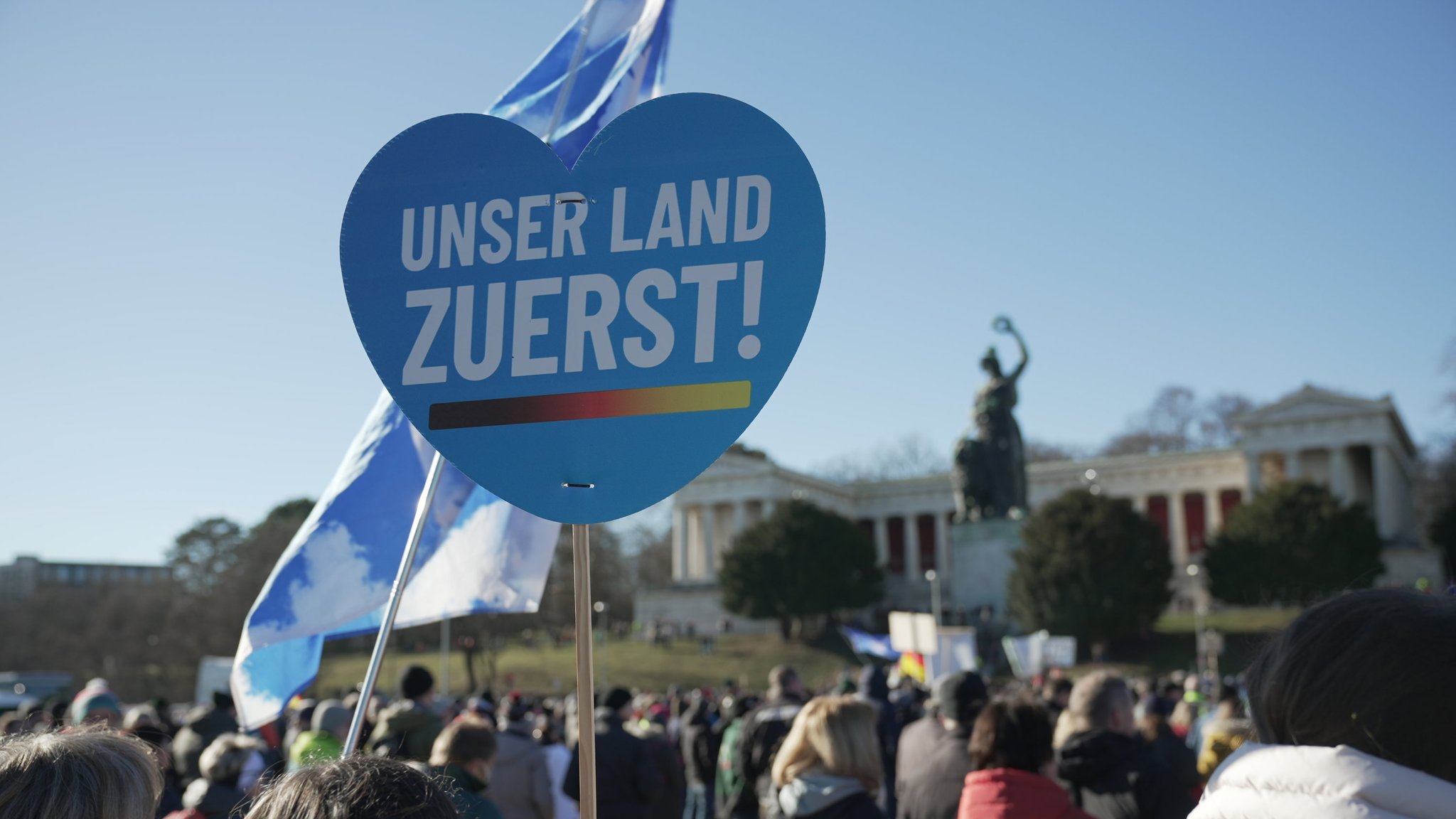 Zu sehen ist ein Plakat mit der Aufschrift "Unser Land zuerst". 