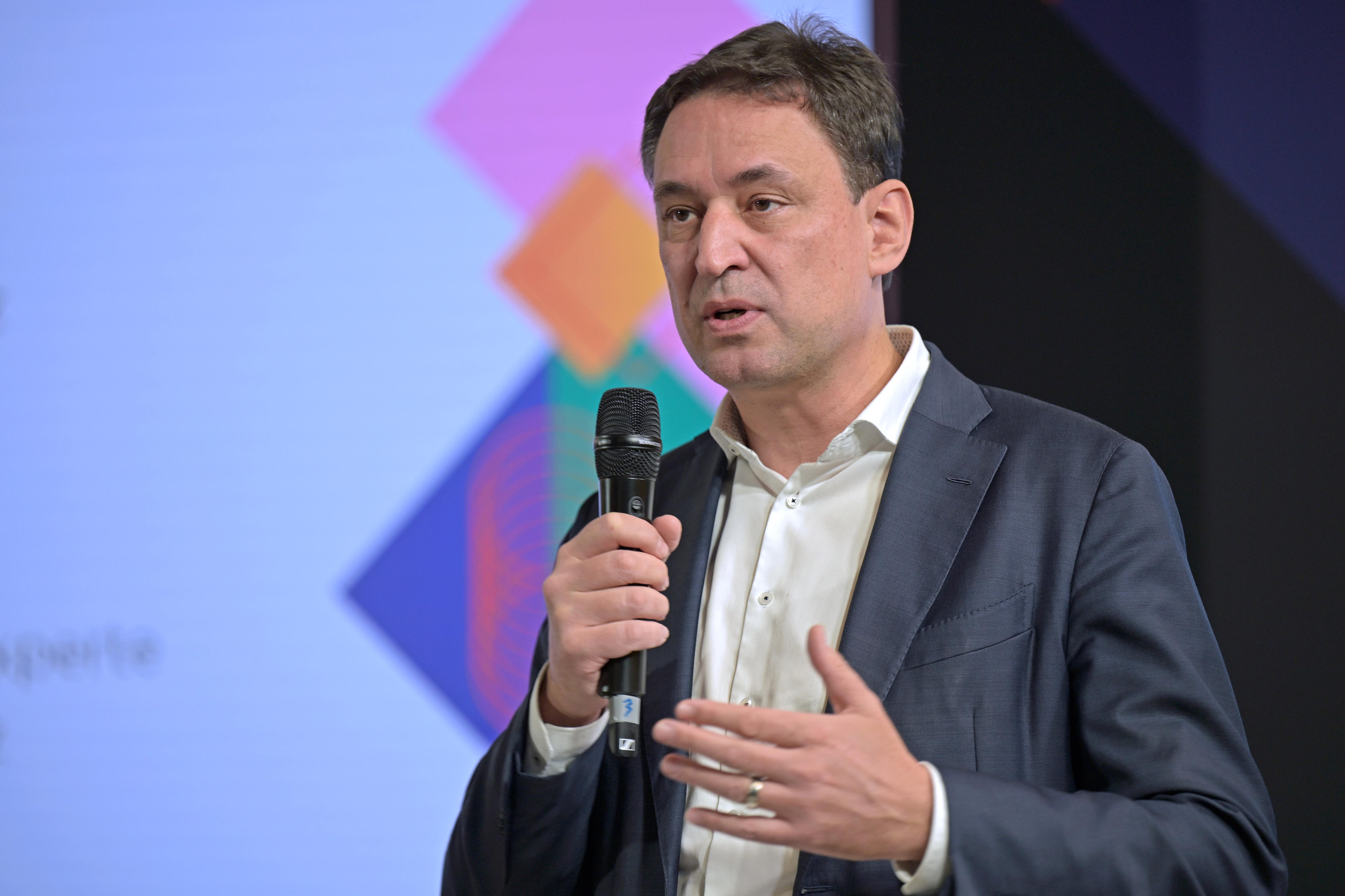 Der bayerische Justizminister hält eine Rede mit Mikrophon in der Hand. 