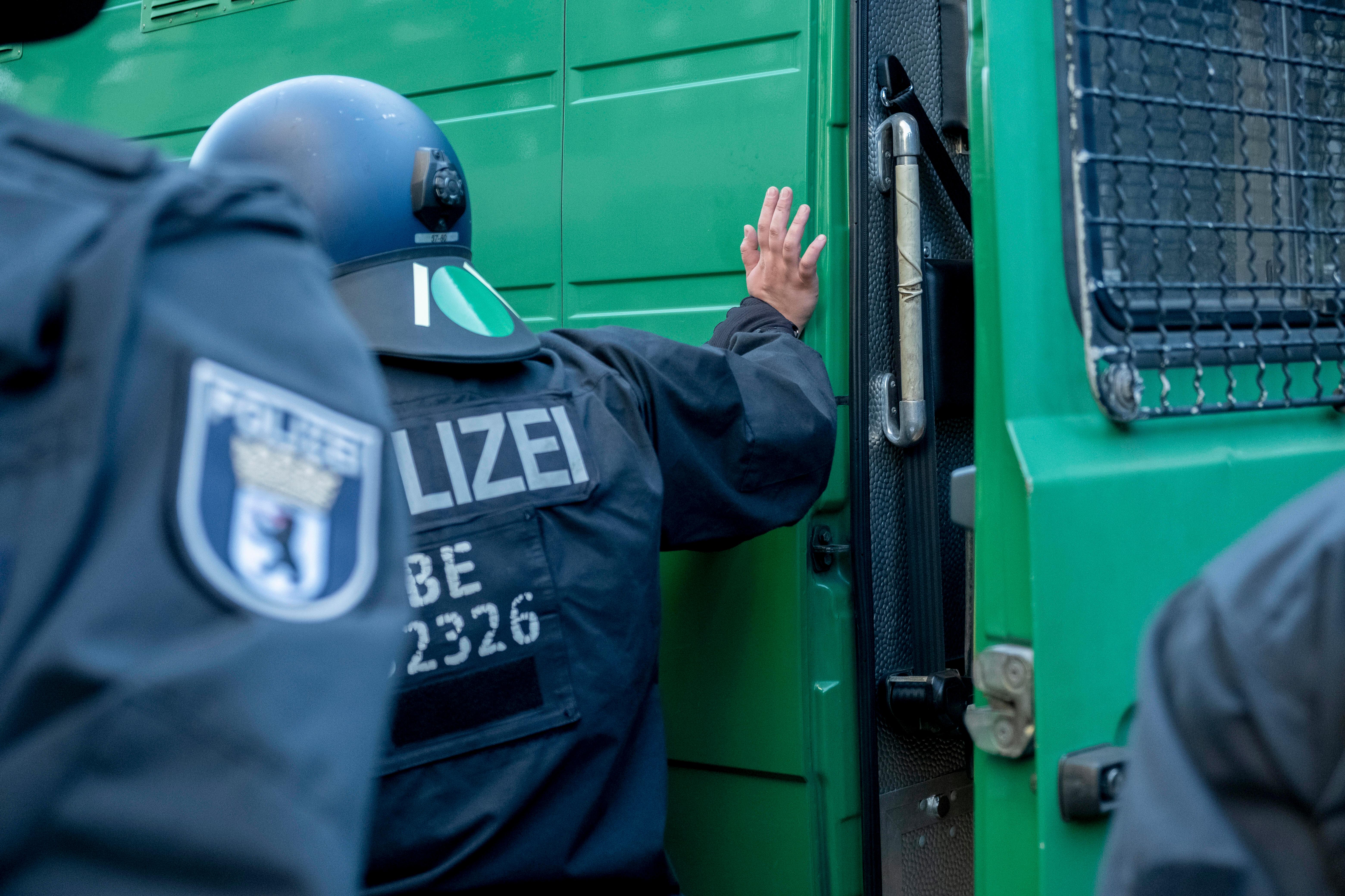 Beamte der Berliner Polizei an einem Polizeibus.