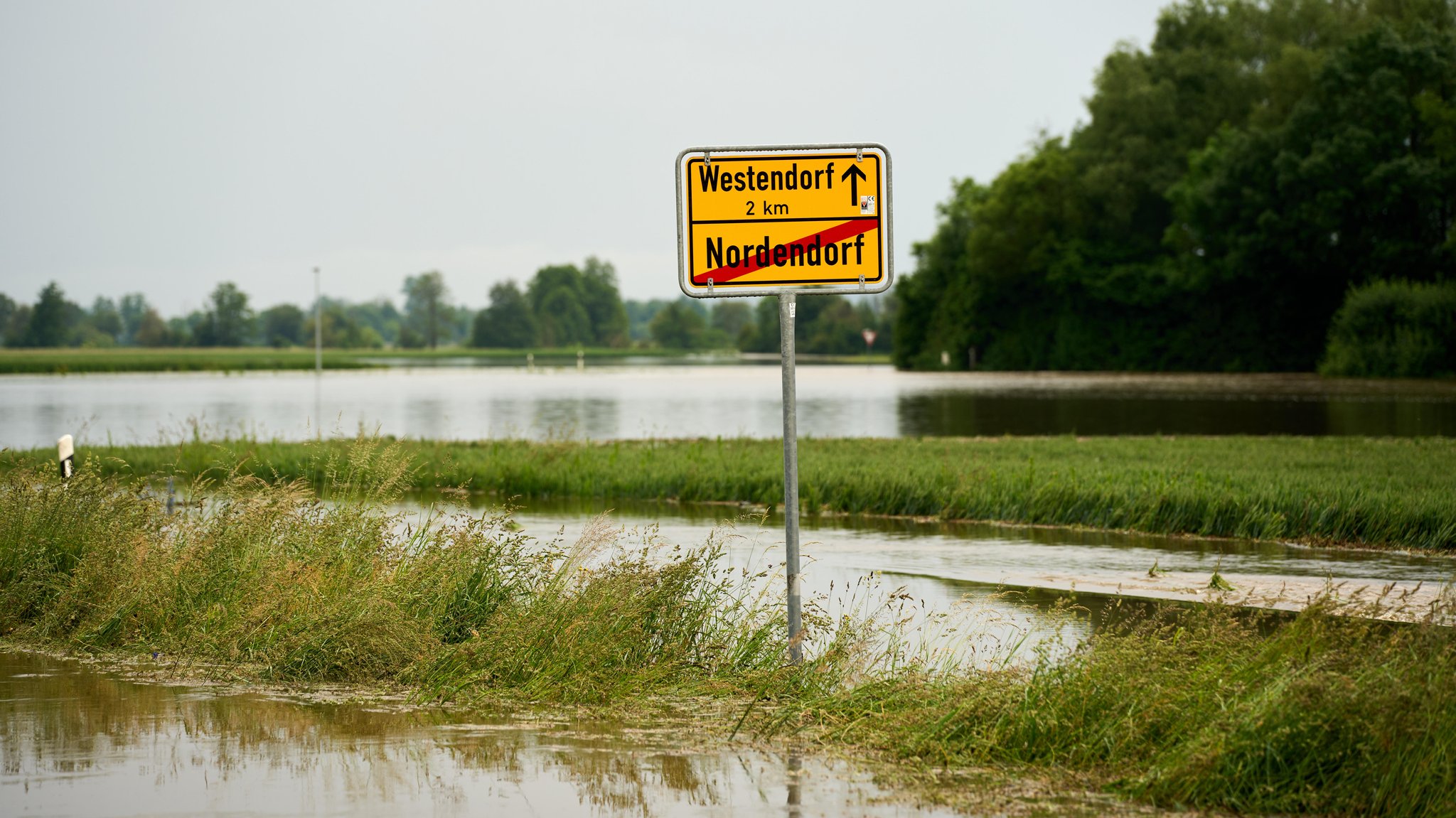 Das Ortsausgangsschild von Nordendorf und die vom Hochwasser überspülten Straßen und Wiesen.