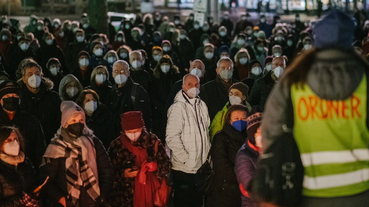 Menschen mit Maske bei einer Kundgebung. 