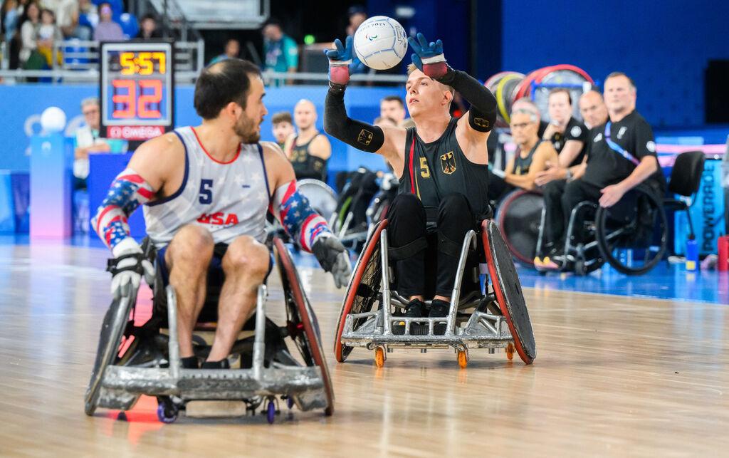 31.08.2024, Frankreich, Paris: Paralympics, Paris 2024, Rollstuhlrugby, Arena Champ de Mars, Gruppe A, Vorrunde, Deutschland - USA, Josco Wilke (r) aus Deutschland spielt den Ball neben Chuck Aoki aus den USA. Foto: Julian Stratenschulte/dpa +++ dpa-Bildfunk +++