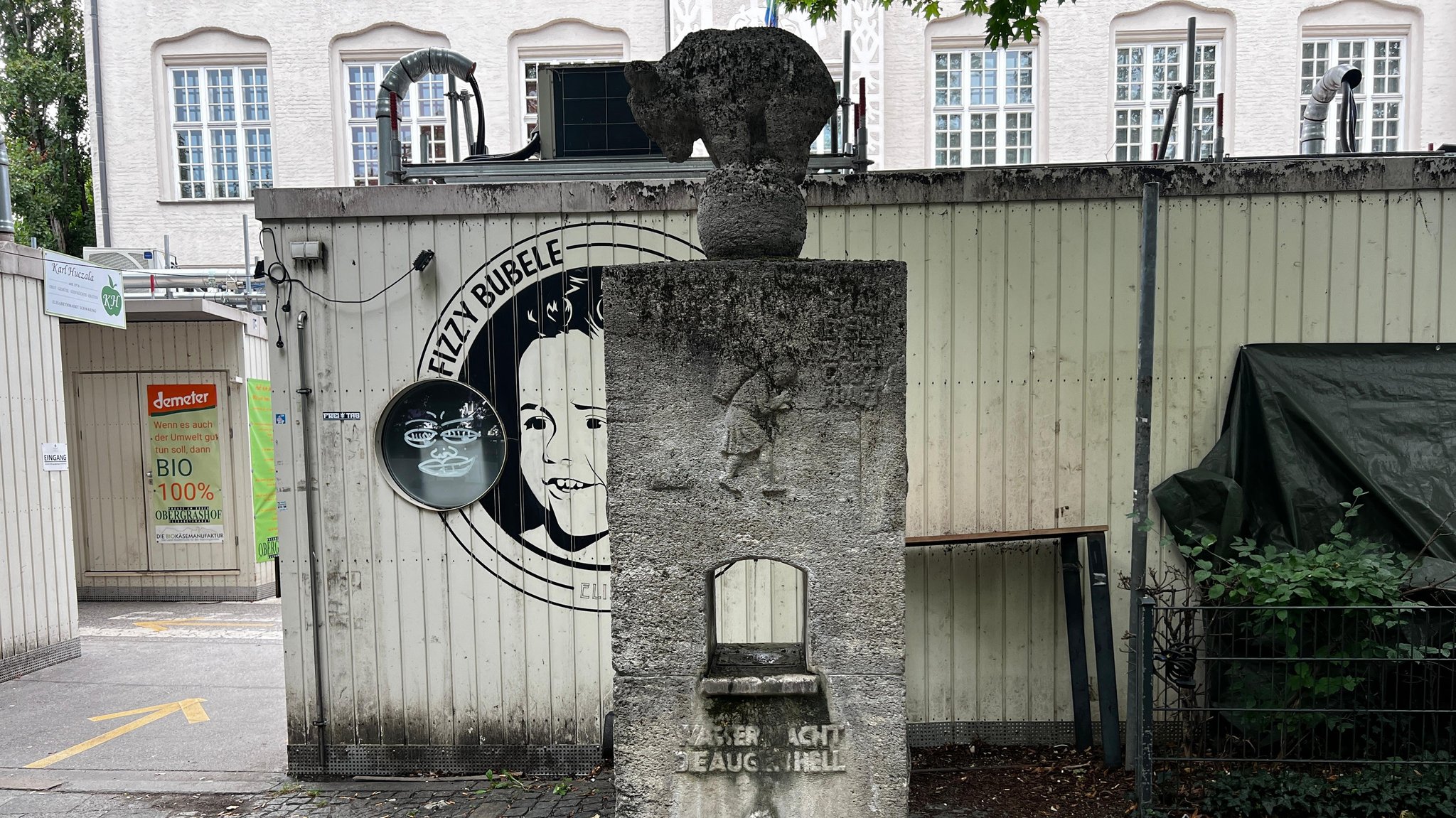 Der alte Trinkwasserbrunnen am Elisabethplatz in München-Schwabing ist verziert mit Sprüchen über das kühle Nass. 