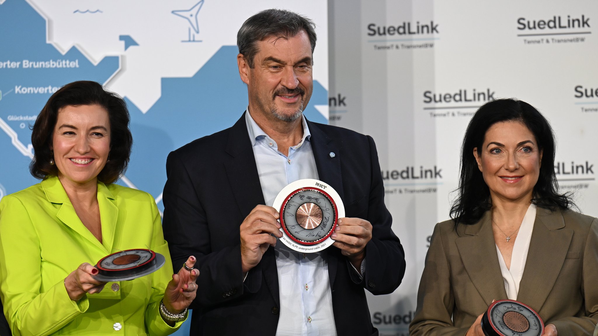 Dorothee Bär (l-r, CSU), Bundesforschungsministerin, Markus Söder (CSU), Ministerpräsident von Bayern, und Katherina Reiche (CDU), Bundeswirtschaftsministerin, halten Scheiben des Erdkabels in den Händen beim feierlichen Baubeginn für SuedLink in Bayern. | Bild: picture alliance/dpa | Martin Schutt Dorothee Bär (l-r, CSU), Bundesforschungsministerin, Markus Söder (CSU), Ministerpräsident von Bayern, und Katherina Reiche (CDU), Bundeswirtschaftsministerin, halten Scheiben des Erdkabels in den Händen beim feierlichen Baubeginn für SuedLink in Bayern.
