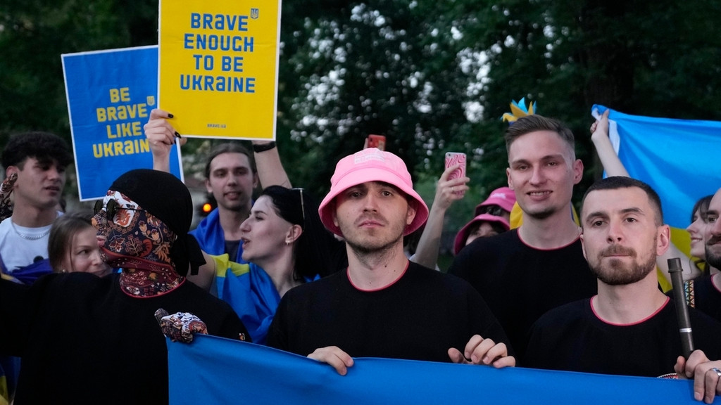 Die Band Kalush Orchestra aus der Ukraine hält die ukrainische Flagge und Plakate mit der Aufschrift "Brave enough to be ukraine" hoch, als sie während eines Flashmobs im Eurovision Village auf die ukrainische Gemeinde trifft. 