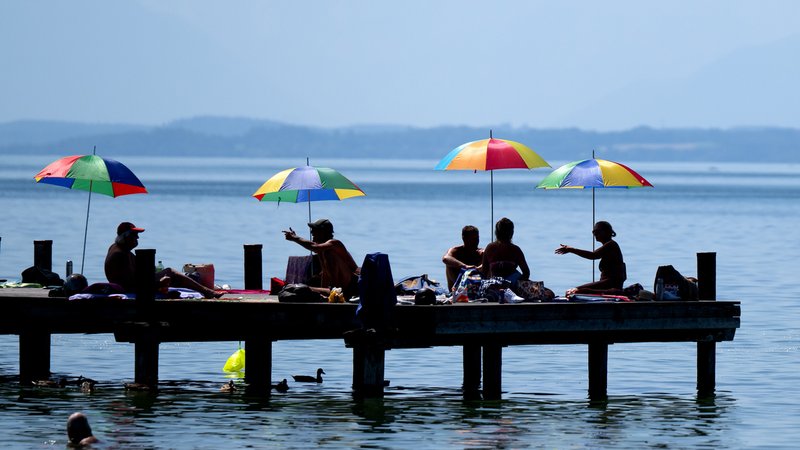 Menschen unter Sonnenschirmen auf einem Steg am Starnberger See | Bild: picture alliance/dpa | Sven Hoppe Menschen unter Sonnenschirmen auf einem Steg am Starnberger See