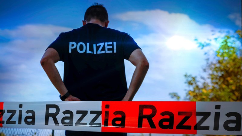 Ein Polizist an einem Einsatzort, der mit einem Absperrband gesichert wurde. | Bild: pa/CHROMORANGE/Michael Bihlmayer Ein Polizist an einem Einsatzort, der mit einem Absperrband gesichert wurde.