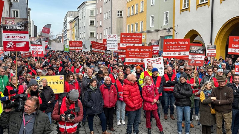 Eine Menschenmenge in der Rosenheimer Innenstadt – die Menschen halten Schilder