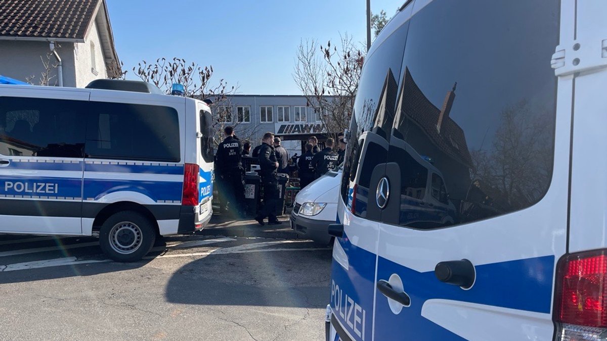 Polizeibeamte durchsuchen Grundstück im Würzburger Stadtteil Sanderau.