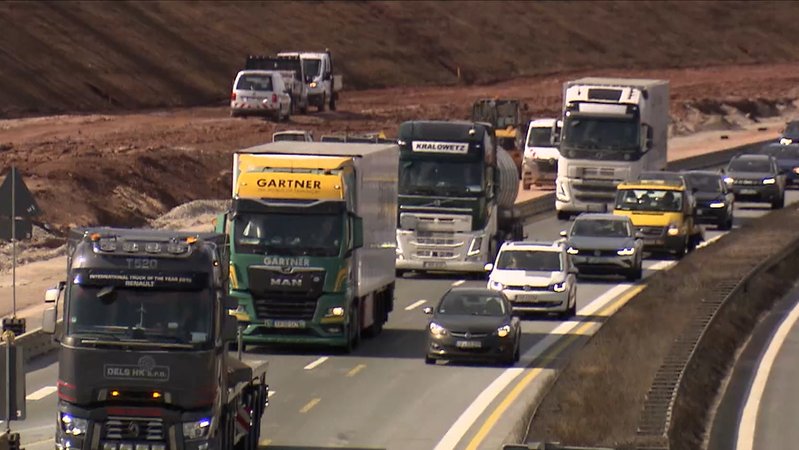 Mehrere Lastwagen sind auf einer Autobahn unterwegs. 