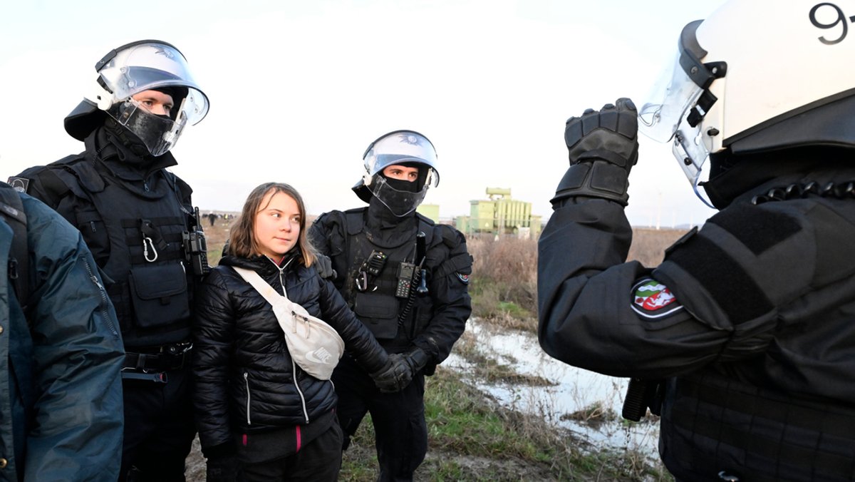 Polizisten bringen die schwedische Klimaaktivistin Greta Thunberg vom Rand des Braunkohlentagebaus Garzweiler II weg.