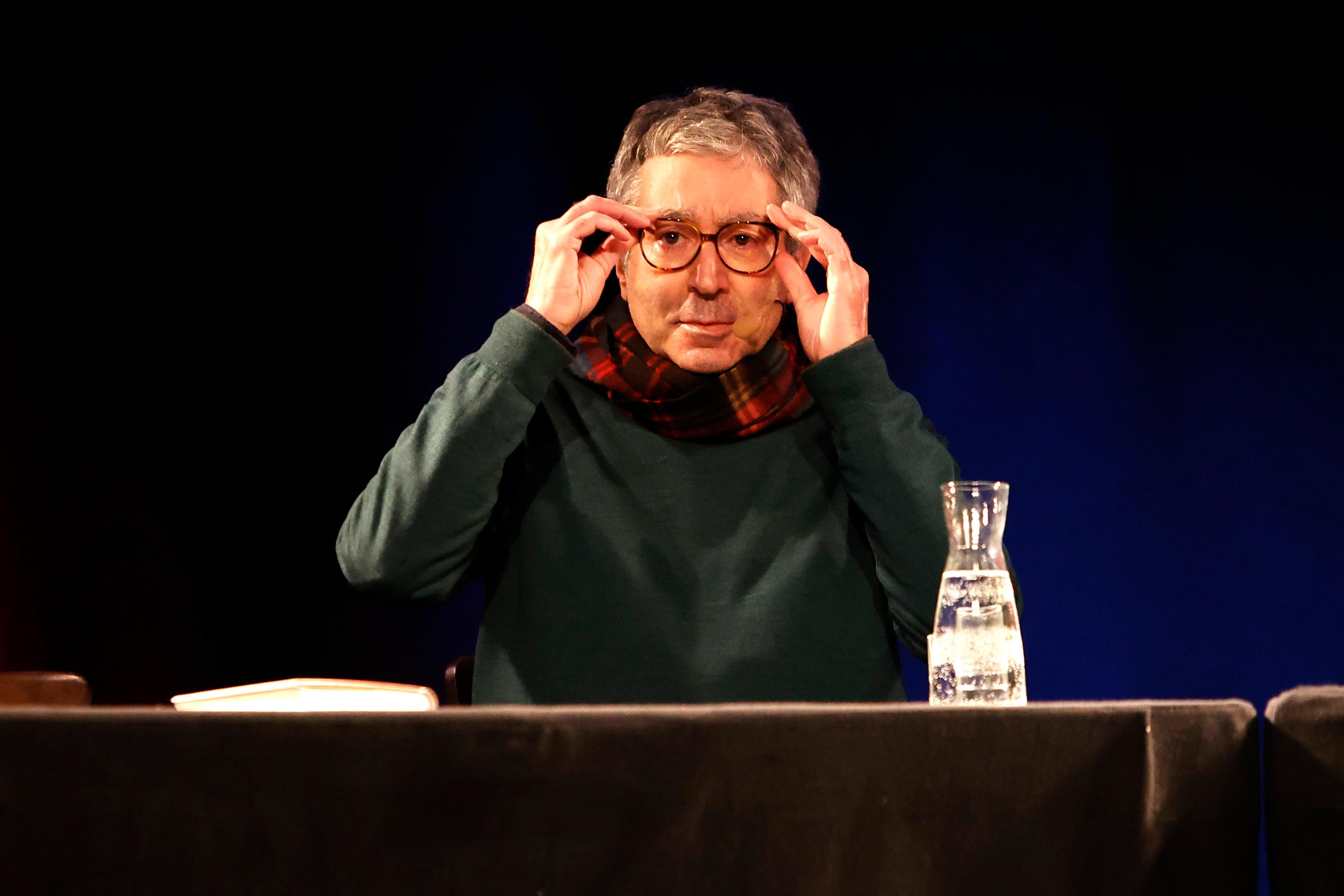 Ein Mann fasst sich an die Brille.