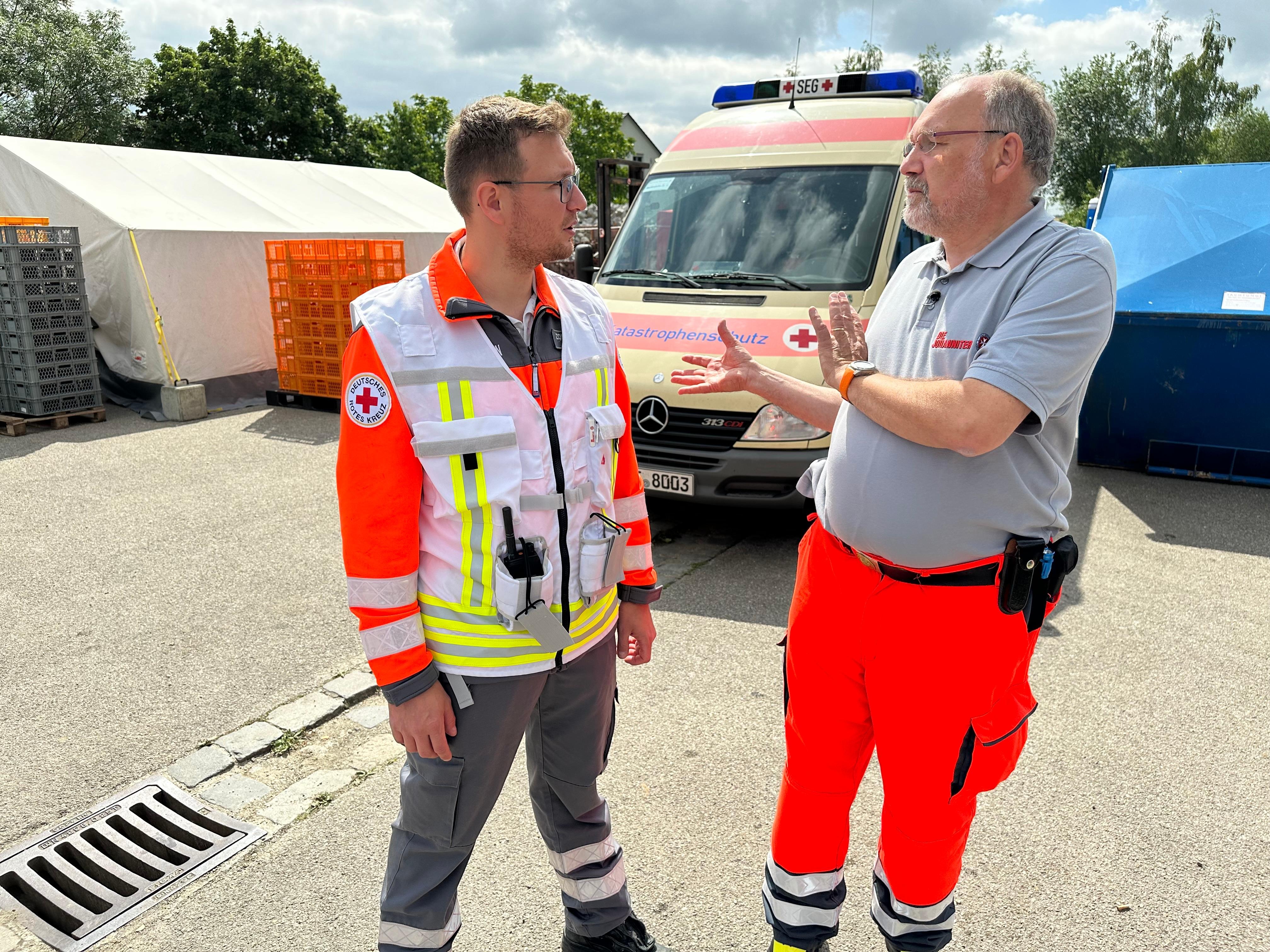 Pfarrer Klaus Kuhn (rechts) im Gespräch mit einem Helfer des Deutschen Roten Kreuzes.