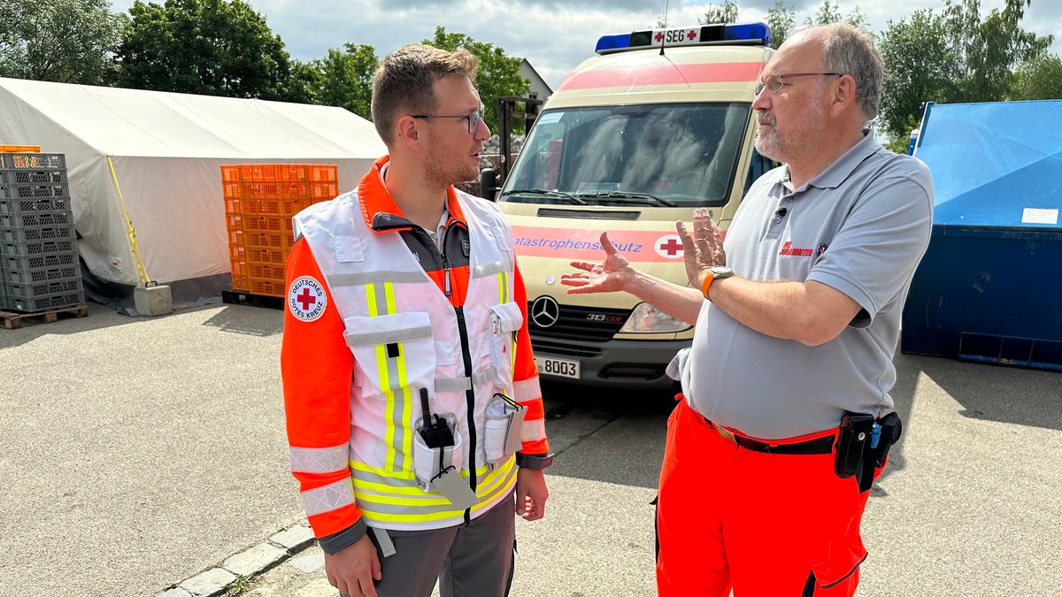 Pfarrer Klaus Kuhn (rechts) im Gespräch mit einem Helfer des Deutschen Roten Kreuzes.