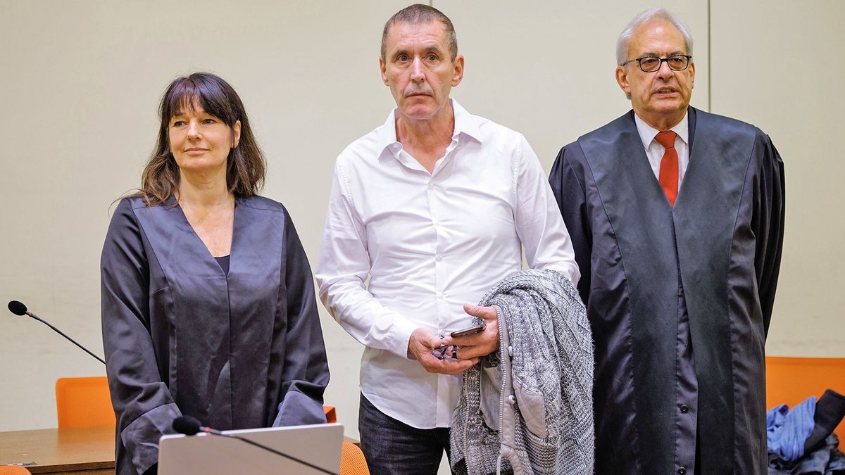 Manfred Genditzki steht vor Prozessbeginn zwischen seinen Anwälten Regina Rick und Klaus Wittmann