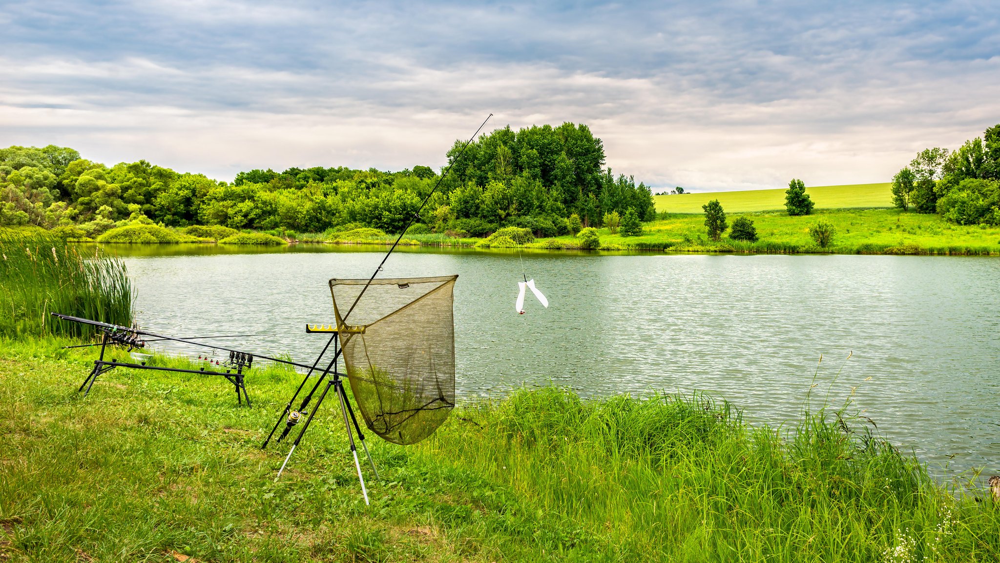 Ein Weiher, an dessen Rand Anglerzubehör steht. | Bild: pa/Shotshop | Kateryna Kolesnyk Ein Weiher, an dessen Rand Anglerzubehör steht.