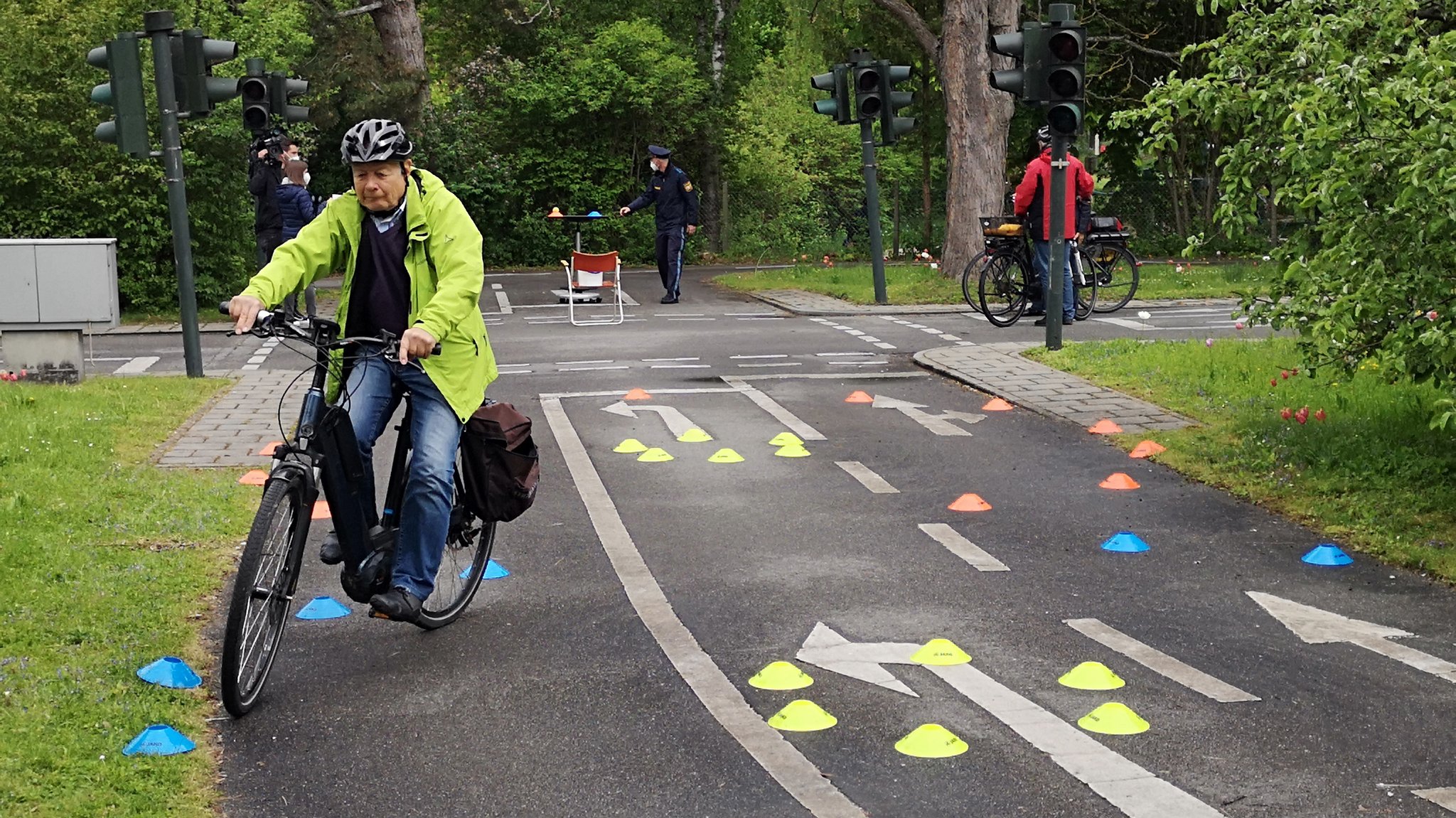 Senioren fahren mit ihren E-Bikes einen bunten Slalom.