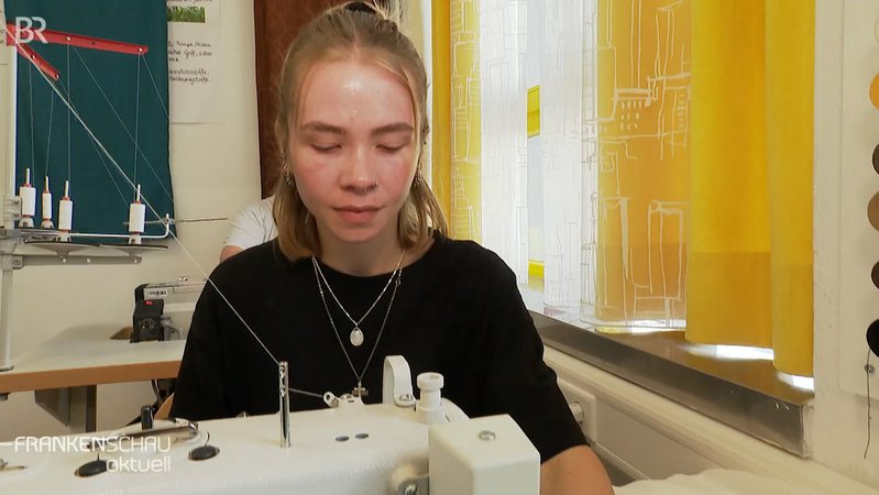 Eine Jugendliche bei der Arbeit an einer Nähmaschine bein SOS-Kinderdorf. | Bild: BR Eine Jugendliche bei der Arbeit an einer Nähmaschine bein SOS-Kinderdorf.