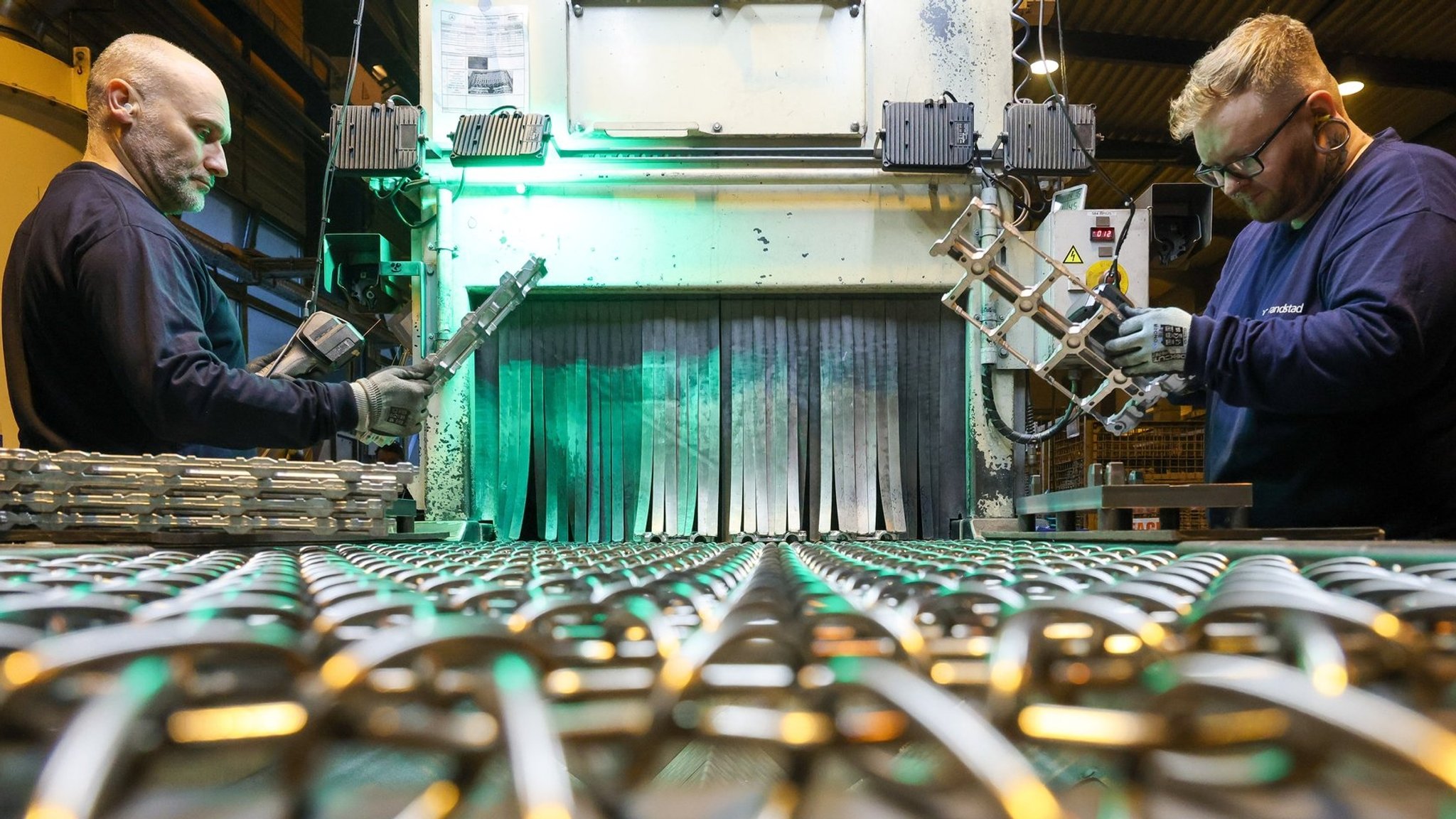 Zwei Arbeiter stellen Gussteile her.