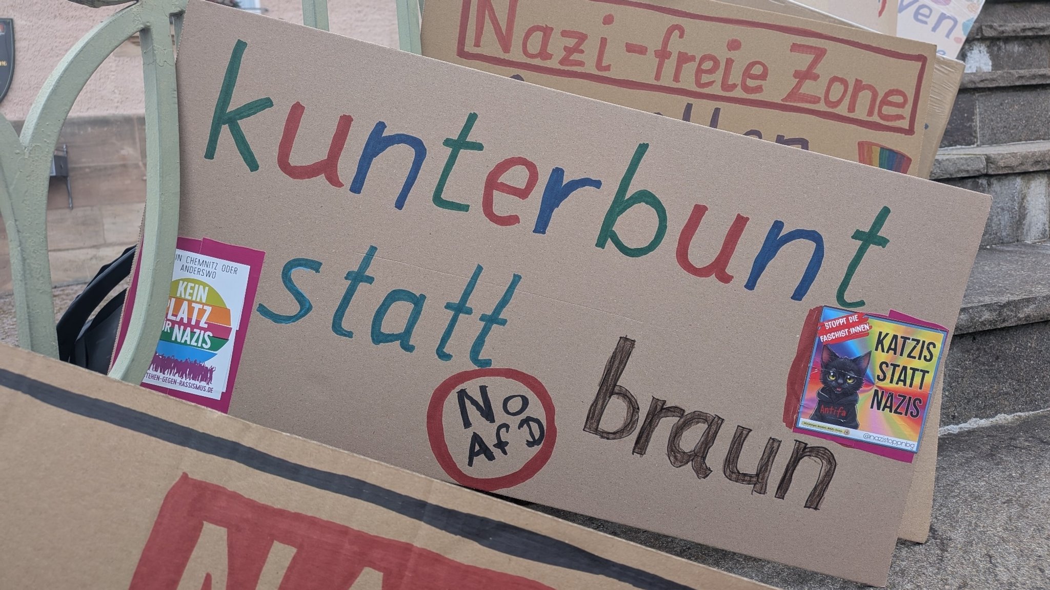 Plakate mit Aufschriften wie "Nazi-freie Zone" und "kunterbunt statt braun" liegen vor dem Cadolzburger Rathaus