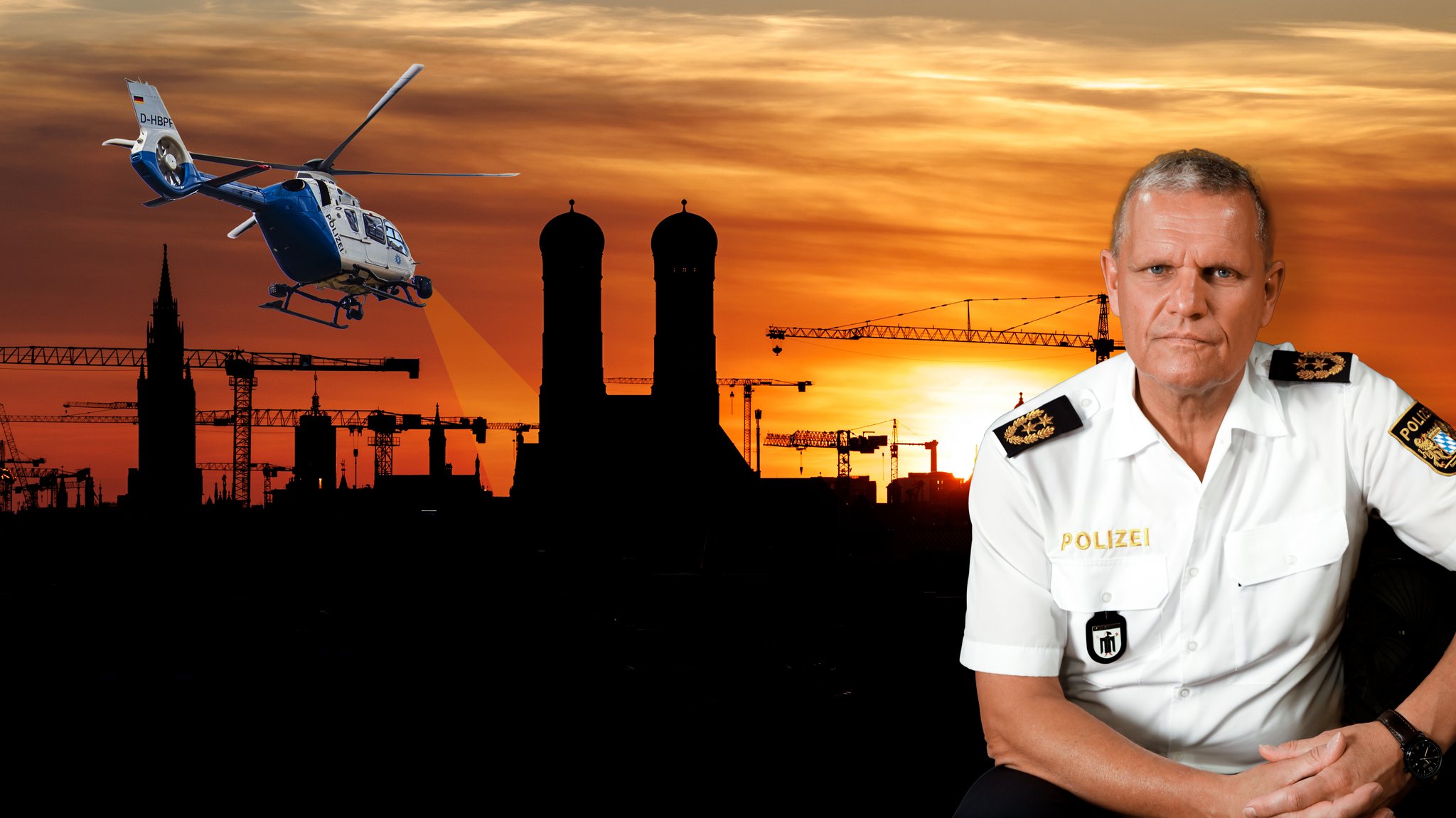 Der Münchner Polizeipräsident Thomas Hampel vor dem Sonnenuntergang hinter der Altstadt von München (Bayern) am 08.04.2025 mit zahlreichen Baukränen. Links daneben ein Polizeihubschrauber.