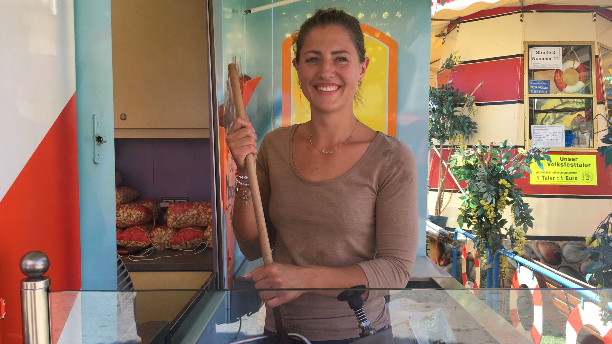 Schaustellerin Tayra Kunstmann stellt auf dem Nürnberger Volksfest Zuckerwatte her.