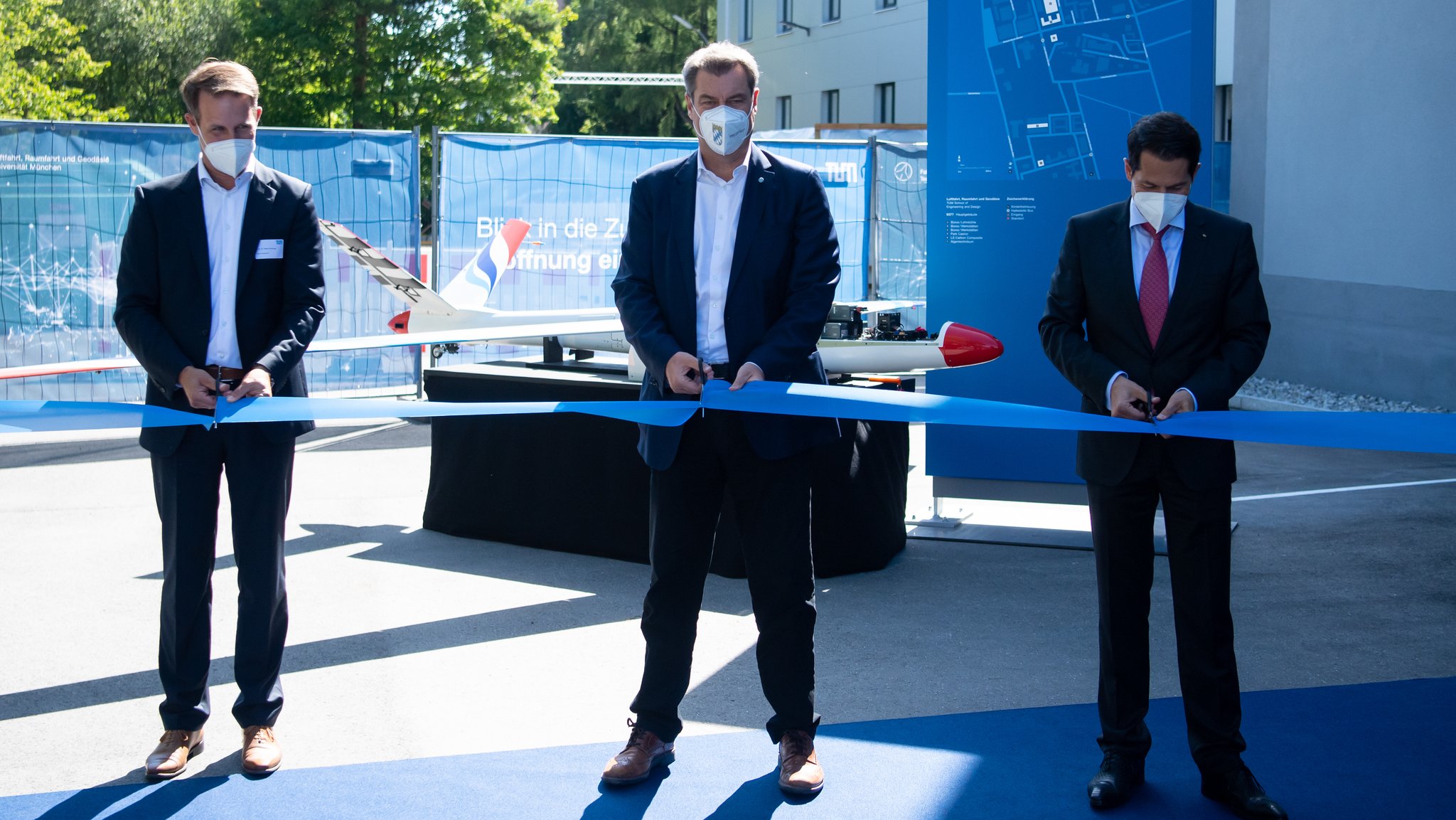 Mirko Hornung (l-r), Dekan an der Technischen Universität München (TUM), Markus Söder (CSU), Ministerpräsident von Bayern, und Thomas F. Hofmann, Präsident der Technischen Universität München (TUM), zerschneiden ein Band bei der Einweihung des neuen Fakultätsgebäudes der Technischen Universität München (TUM) für Luftfahrt, Raumfahrt und Geodäsie.