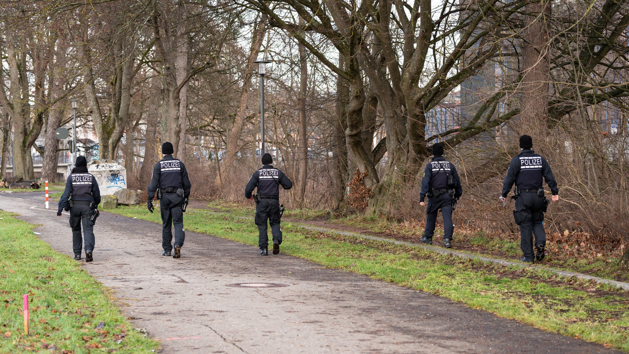 Symbolbild: Polizeibeamte suchen ein Ufer nach einem Vermissten ab.