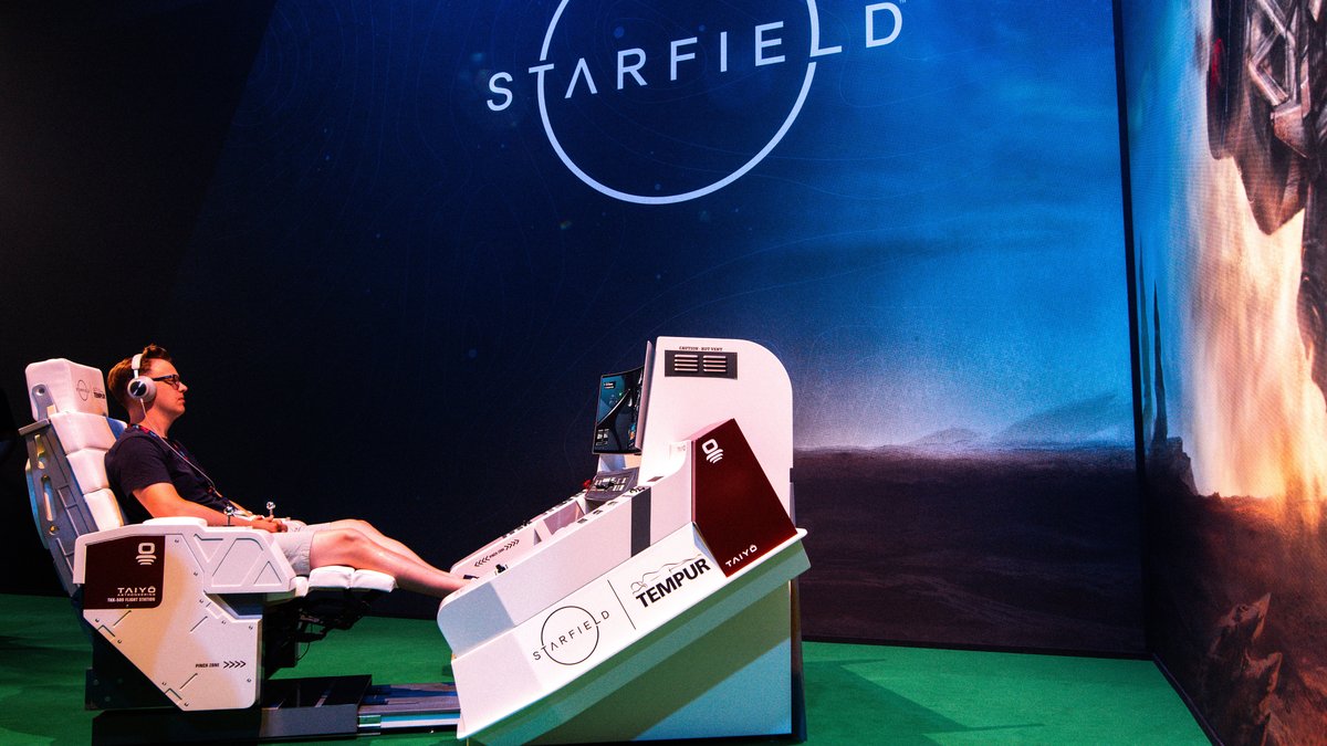Ein junger Mann sitzt auf der Messe Gamescom in einem speziellen Gaming-Stuhl und spielt das neue Spiel "Starfield"