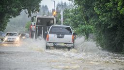 Babenhausen: Autos fahren durch Wasser auf einer überschwemmten Straße. | Bild:dpa-Bildfunk/Jason Tschepljakow