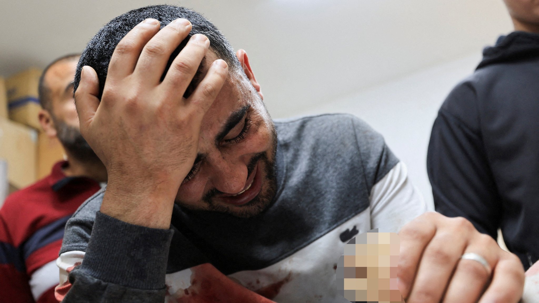 A father mourns next to the body of his three‑year‑old child, Yahya Al‑Malahi, who was killed in an Israeli strike, according to medics, in Gaza City, April 14, 2026.