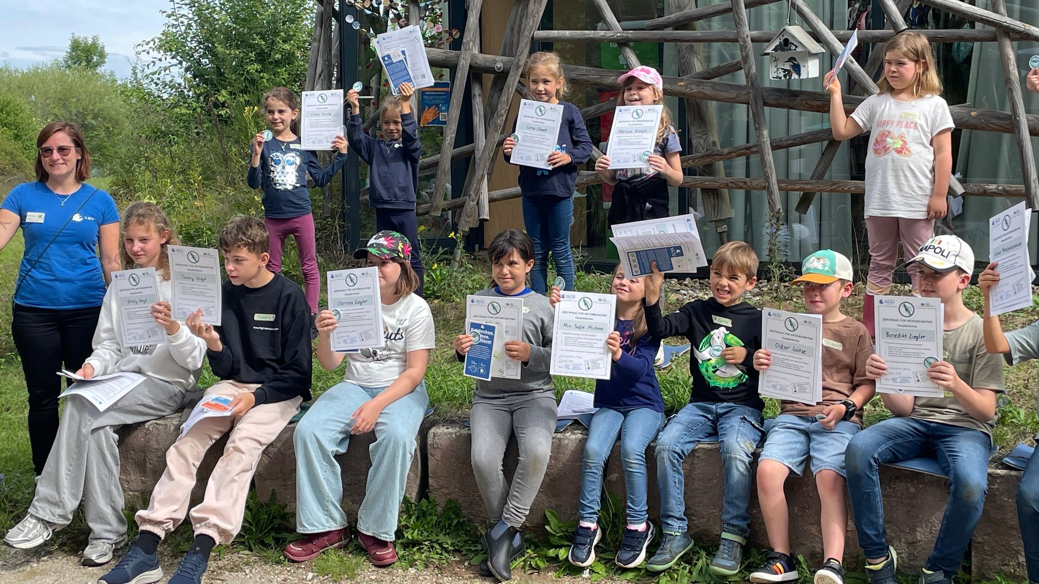 Kinder halten Urkunden mit dem Heupferdchen-Abzeichen in die Höhe