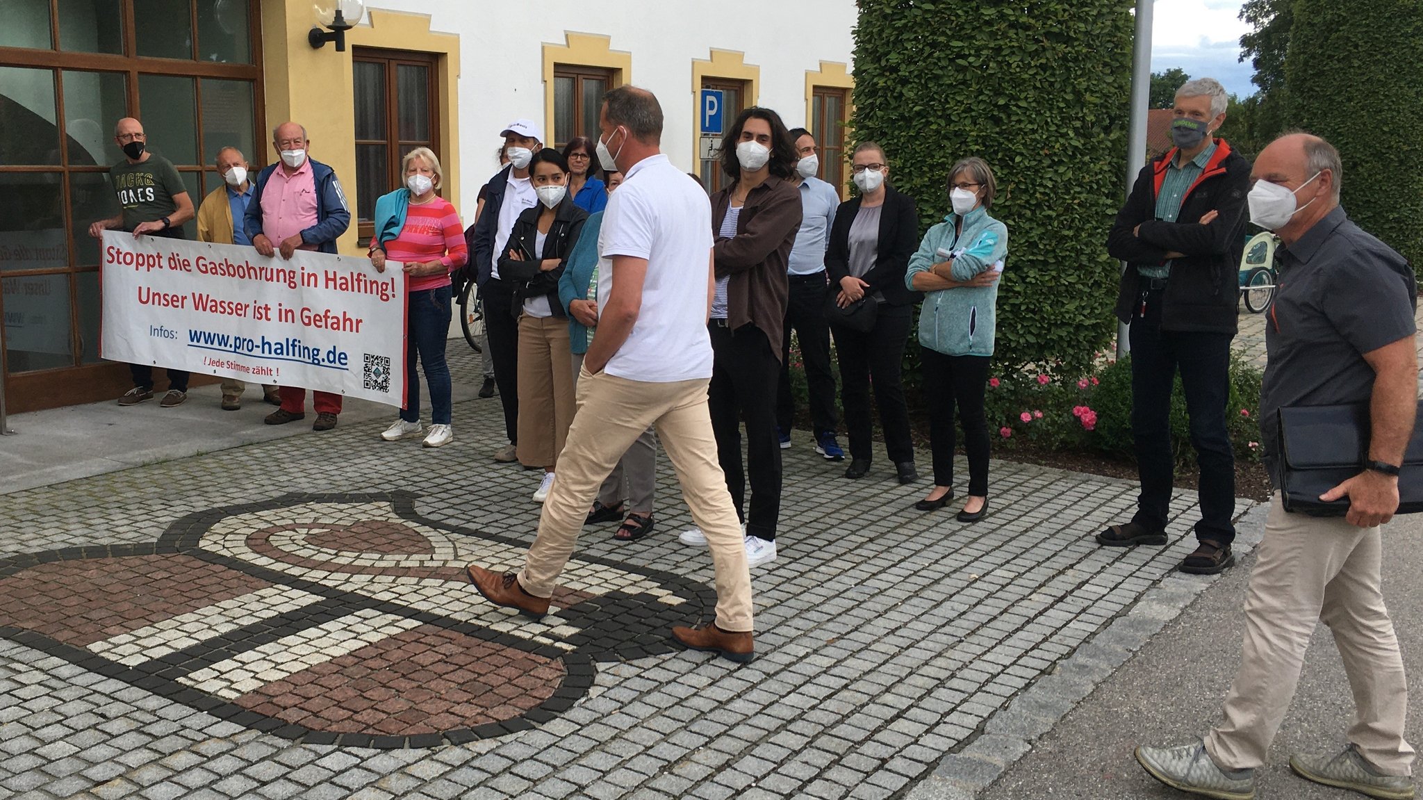 Die Sprecher von Wintershall-Dea werden von den Demonstranten vor dem Gemeindehaus empfangen