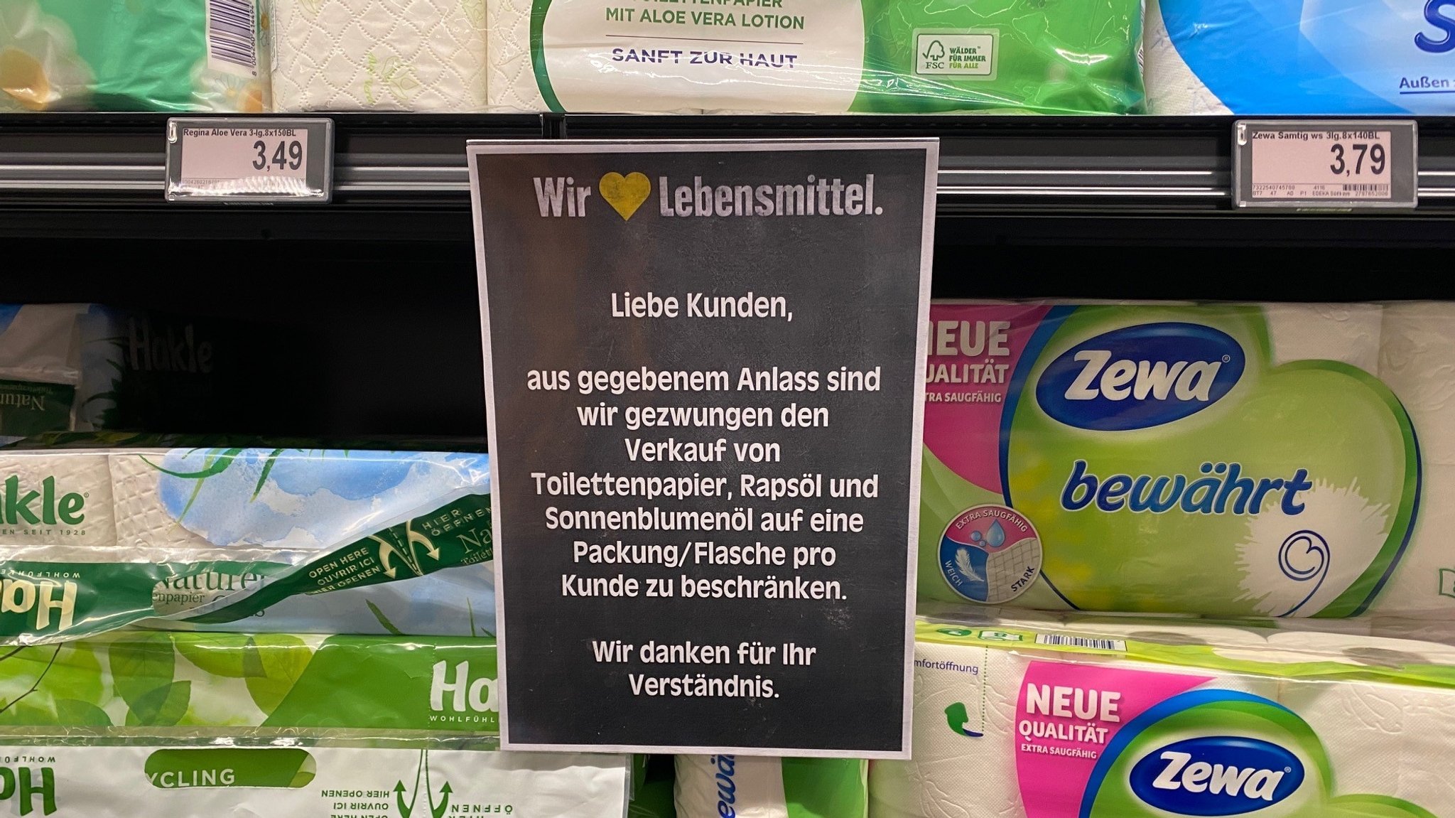 Schild am Supermarkt-Regal. Bei Speiseöl und Toilettenpapier darf nur noch je eine Flasche bzw. Packung gekauft werden.