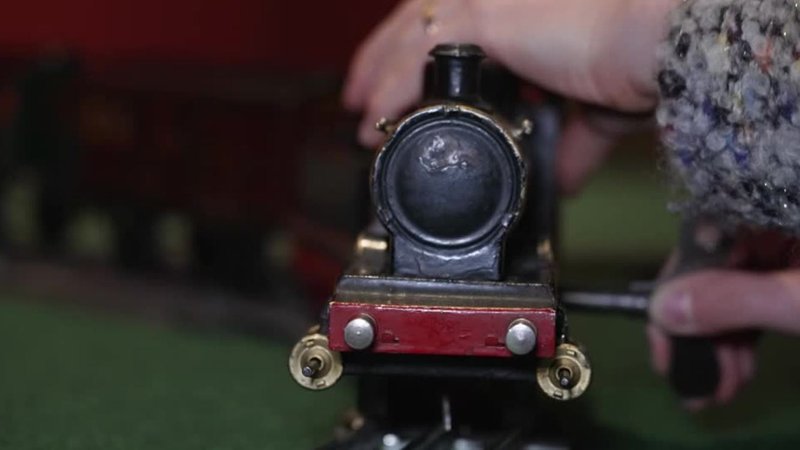 Die Kuratorin der Ausstellung dreht am Uhrwerk einer Modelleisenbahn | Bild: BR/Andreas Matthes Die Kuratorin der Ausstellung dreht am Uhrwerk einer Modelleisenbahn