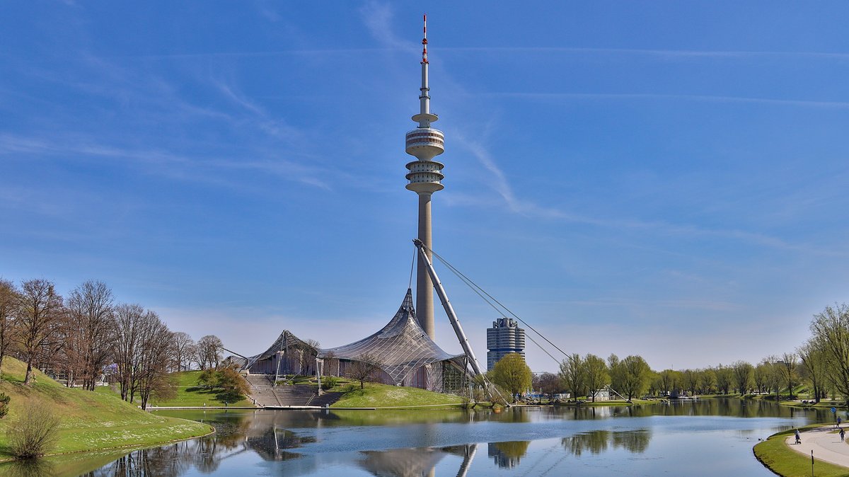 Der Olympiapark in der Landeshauptstadt München, mit Olympiasee und Olympiaturm.