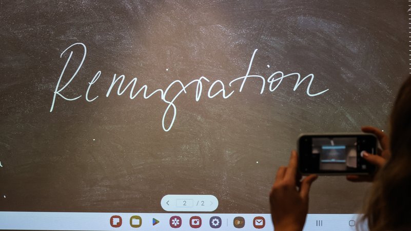 Der Begriff "Remigration" steht bei der Bekanntgabe des "Unwort des Jahres" 2023 auf einem Bildschirm und wird mit einem Smartphone fotografiert. | Bild: pa/dpa/Nadine Weigel Der Begriff "Remigration" steht bei der Bekanntgabe des "Unwort des Jahres" 2023 auf einem Bildschirm und wird mit einem Smartphone fotografiert.