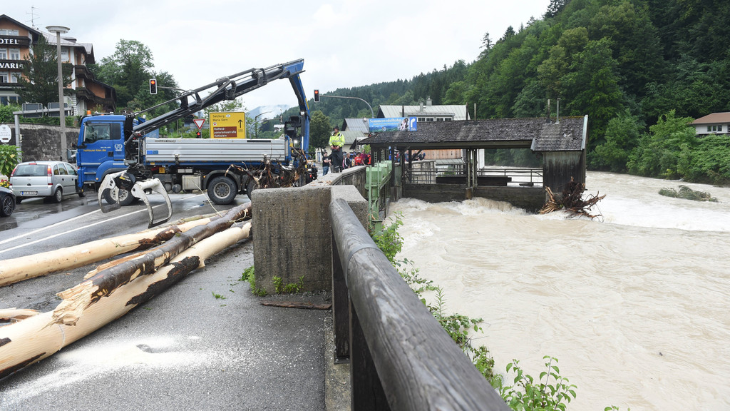 Aufräumen im Berchtesgadener Land: Einsatzkräfte ziehen einen Baumstamm aus dem Wasser.