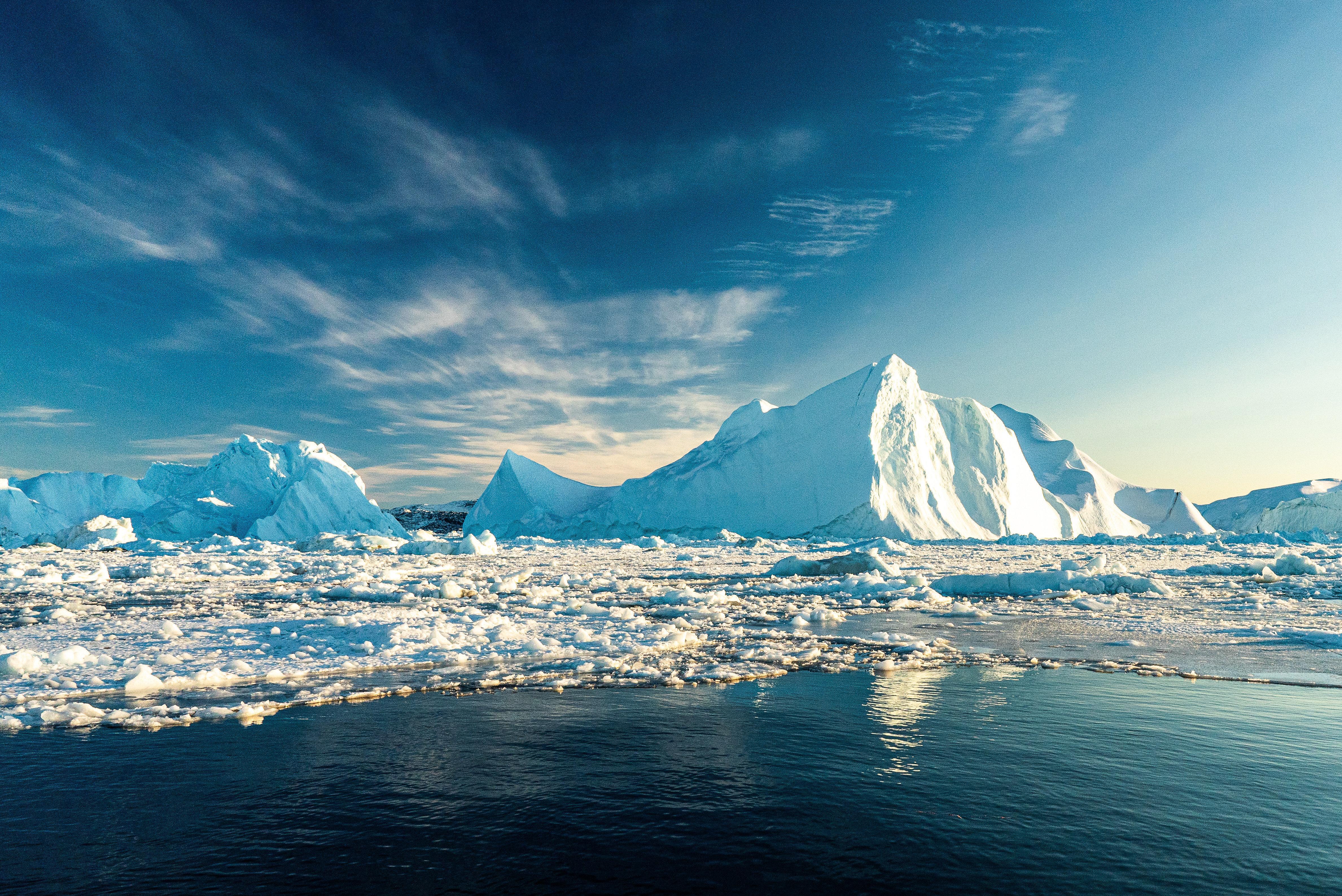 Das Bild zeigt Eisberge nahe von Grönland. Vor allem die arktischen Regionen sind vom Klimawandel jetzt schon stärker betroffen als niedrigere Breitengrade. 