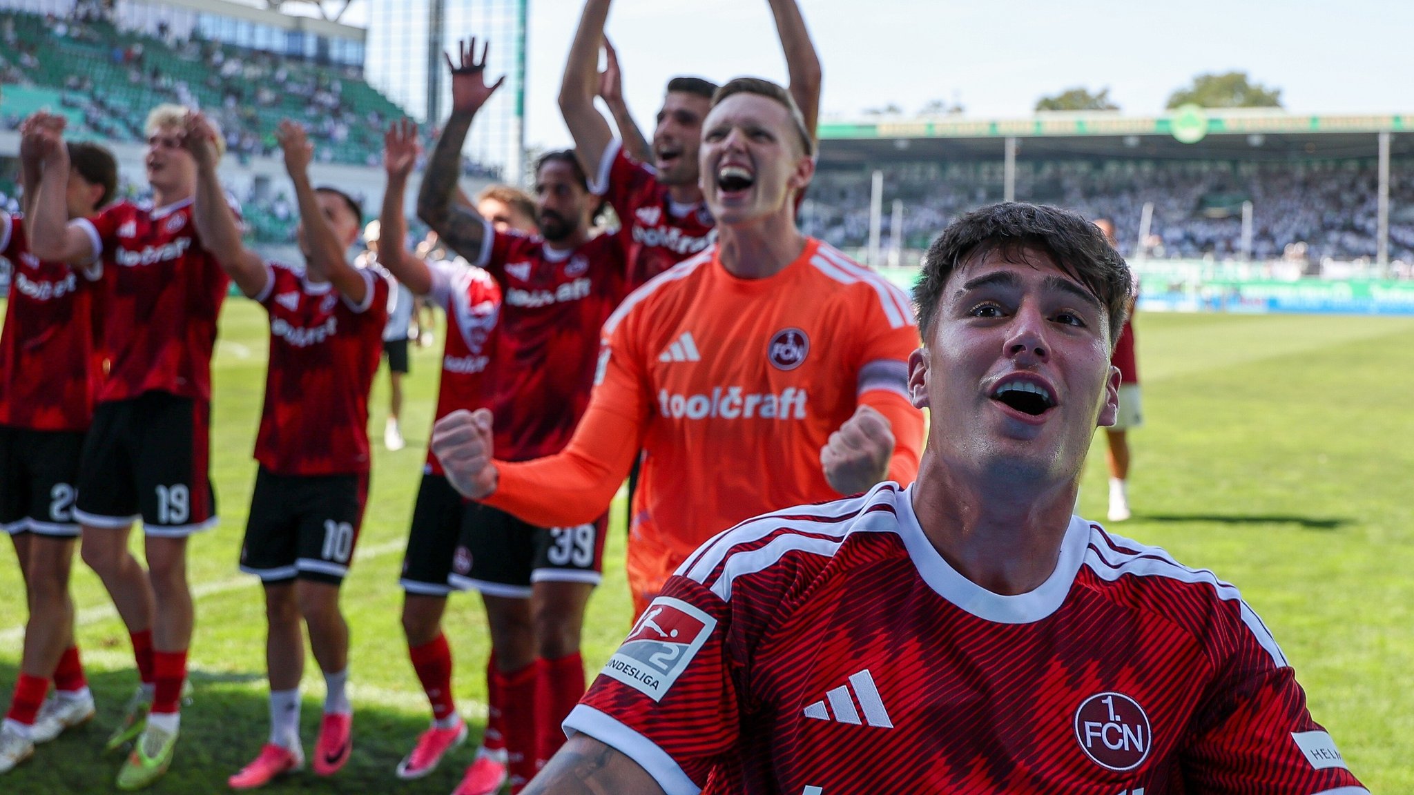 Schlussjubel bei den Nürnberger Fans über den Derbysieg, mit Javier Fernandez #8 (1. FC Nürnberg), Jan Reichert #1 (1. FC Nürnberg), Alexios Kalogeropoulos #4 (1. FC Nürnberg). | Bild: picture alliance / kolbert-press/Martin Agüera | kolbert-press/Martin Agüera Schlussjubel bei den Nürnberger Fans über den Derbysieg, mit Javier Fernandez #8 (1. FC Nürnberg), Jan Reichert #1 (1. FC Nürnberg), Alexios Kalogeropoulos #4 (1. FC Nürnberg).