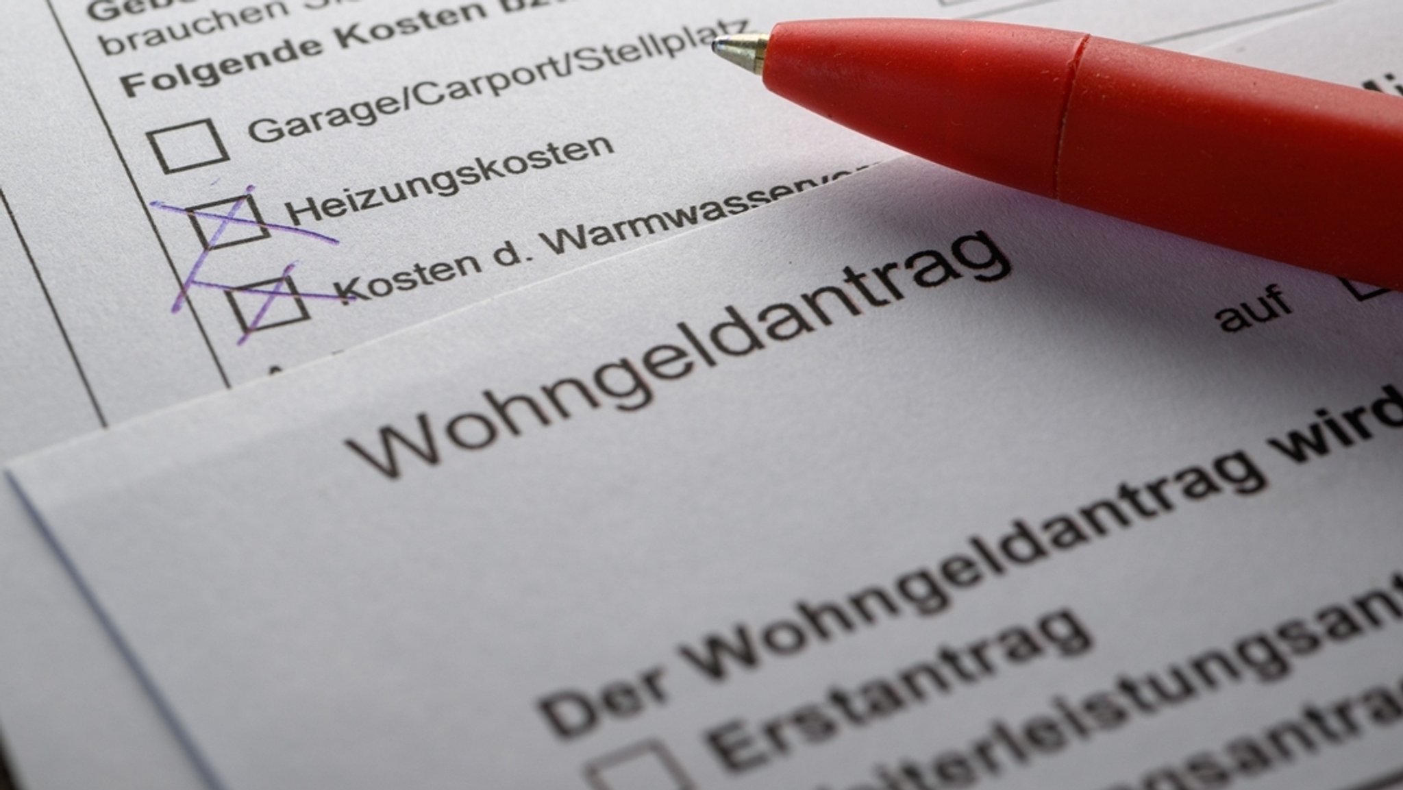 Ein Stift liegt auf einem Wohngeldantrag auf einem Tisch