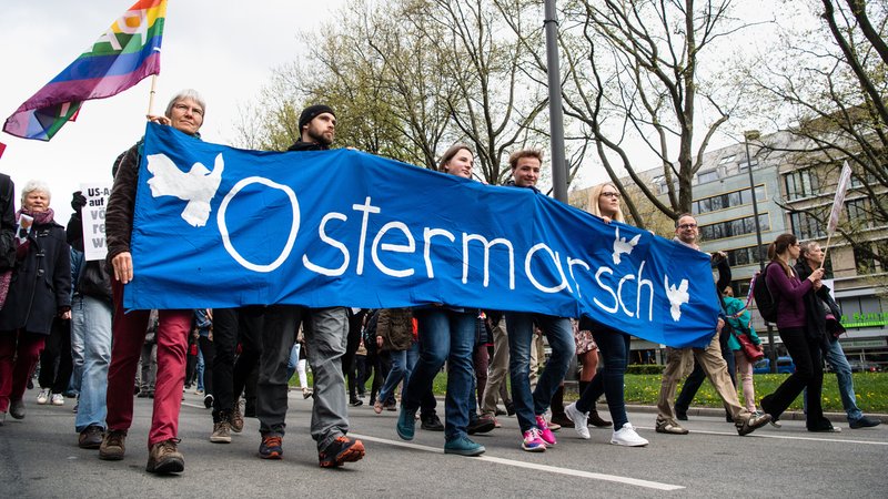 Anhänger der Friedensbewegung tragen am 15.04.2017 beim Ostermarsch in München (Bayern) ein Banner mit der Aufschrift "Ostermarsch". | Bild: picture alliance / Matthias Balk/dpa | Matthias Balk Anhänger der Friedensbewegung tragen am 15.04.2017 beim Ostermarsch in München (Bayern) ein Banner mit der Aufschrift "Ostermarsch".