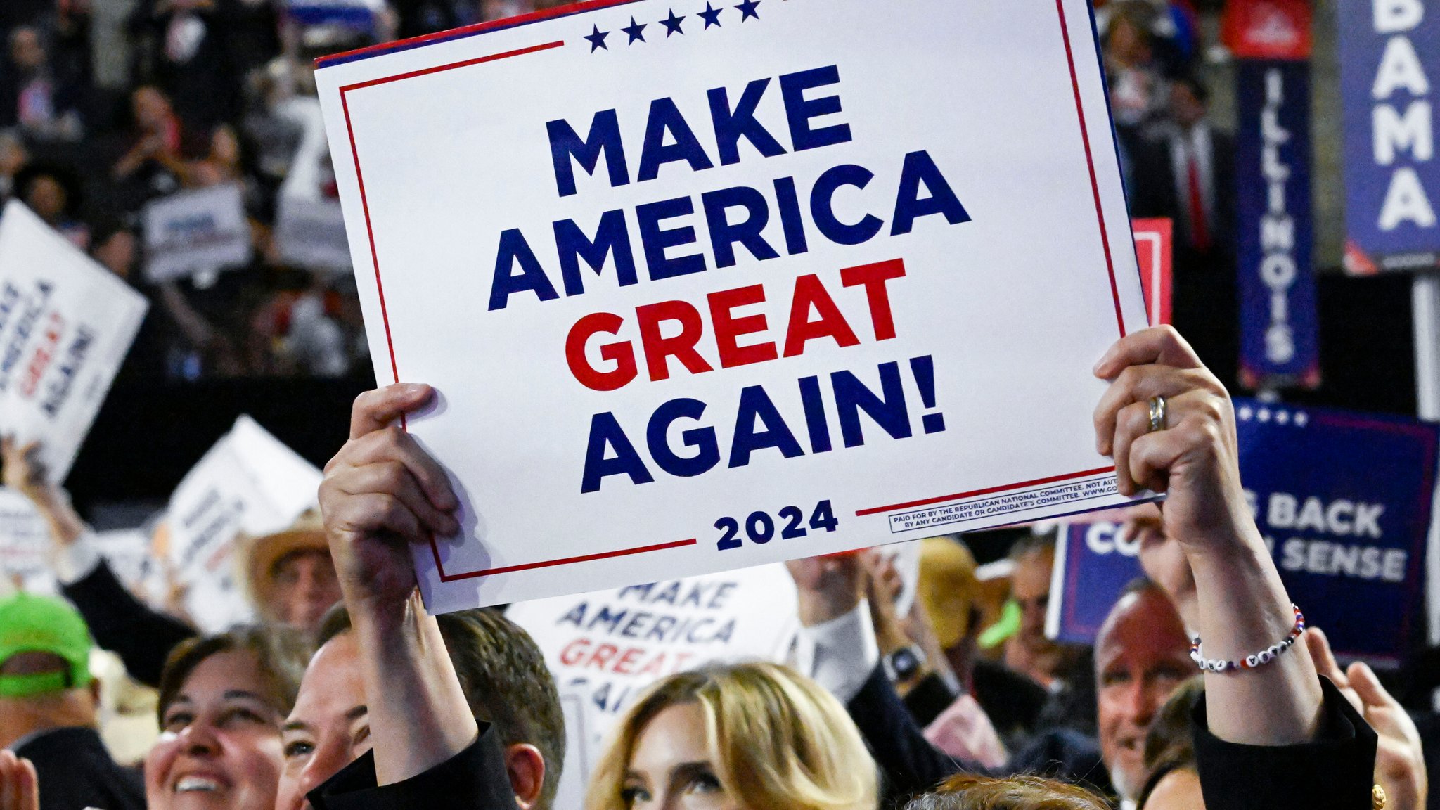 Eine Frau hält ein Schild mit der Aufschrift "Make America Great Again" in die Höhe (Archivbild)