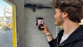 Ein Jugendlicher steht in einer Telefonzelle und scannt einen QR-Code. | Bild:Antonio Jung / BR.de