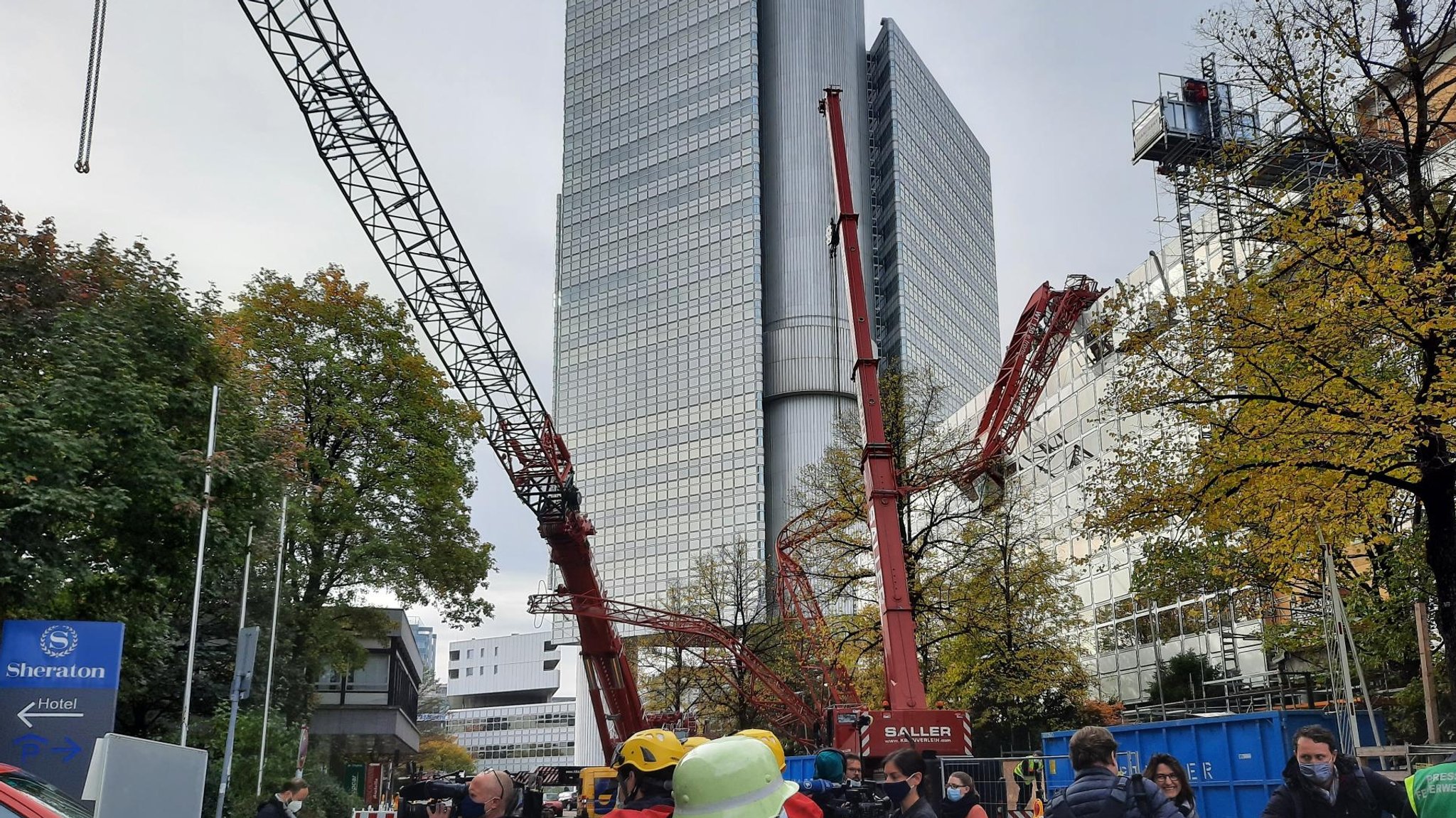 Der abgestürzte Ausleger des Krans liegt auf einem Hausdach im Arabellapark in München.