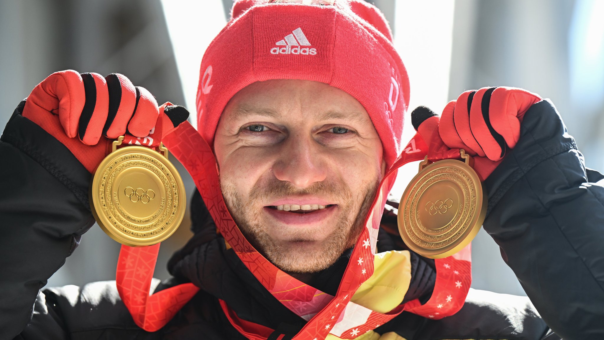 Bobpilot Francesco Friedrich feiert mit seinen Goldmedaillen nach der Siegerehrung. 