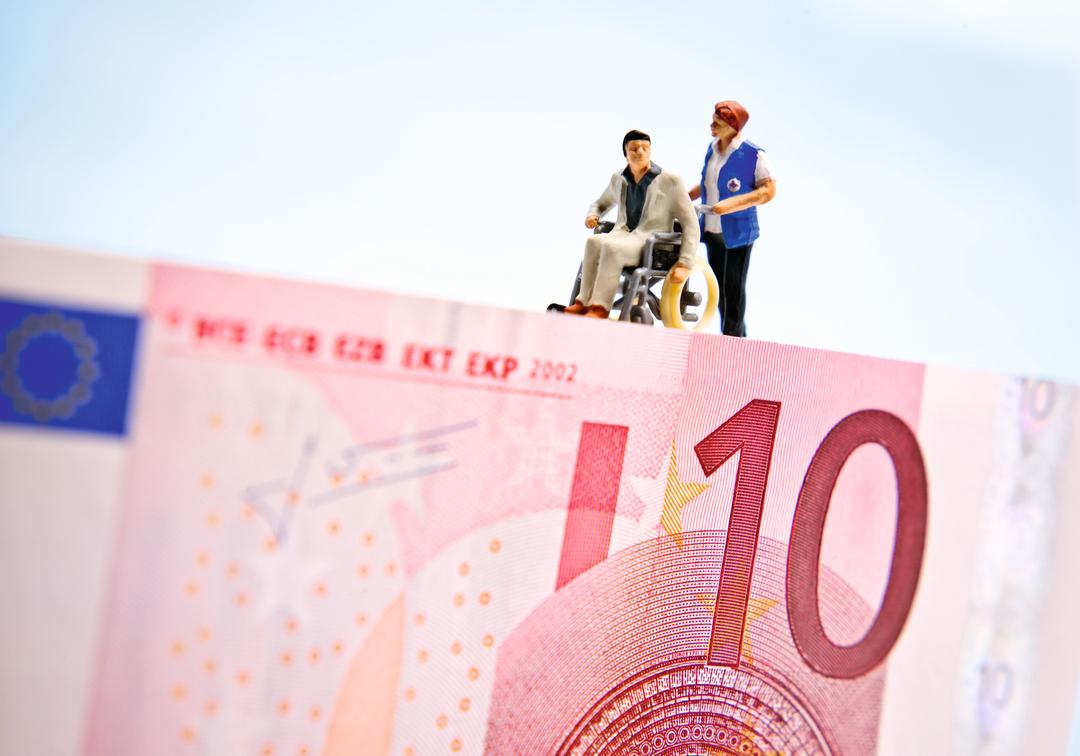 Figuren eines Patienten und einer Pflegerin auf einem Geldschein